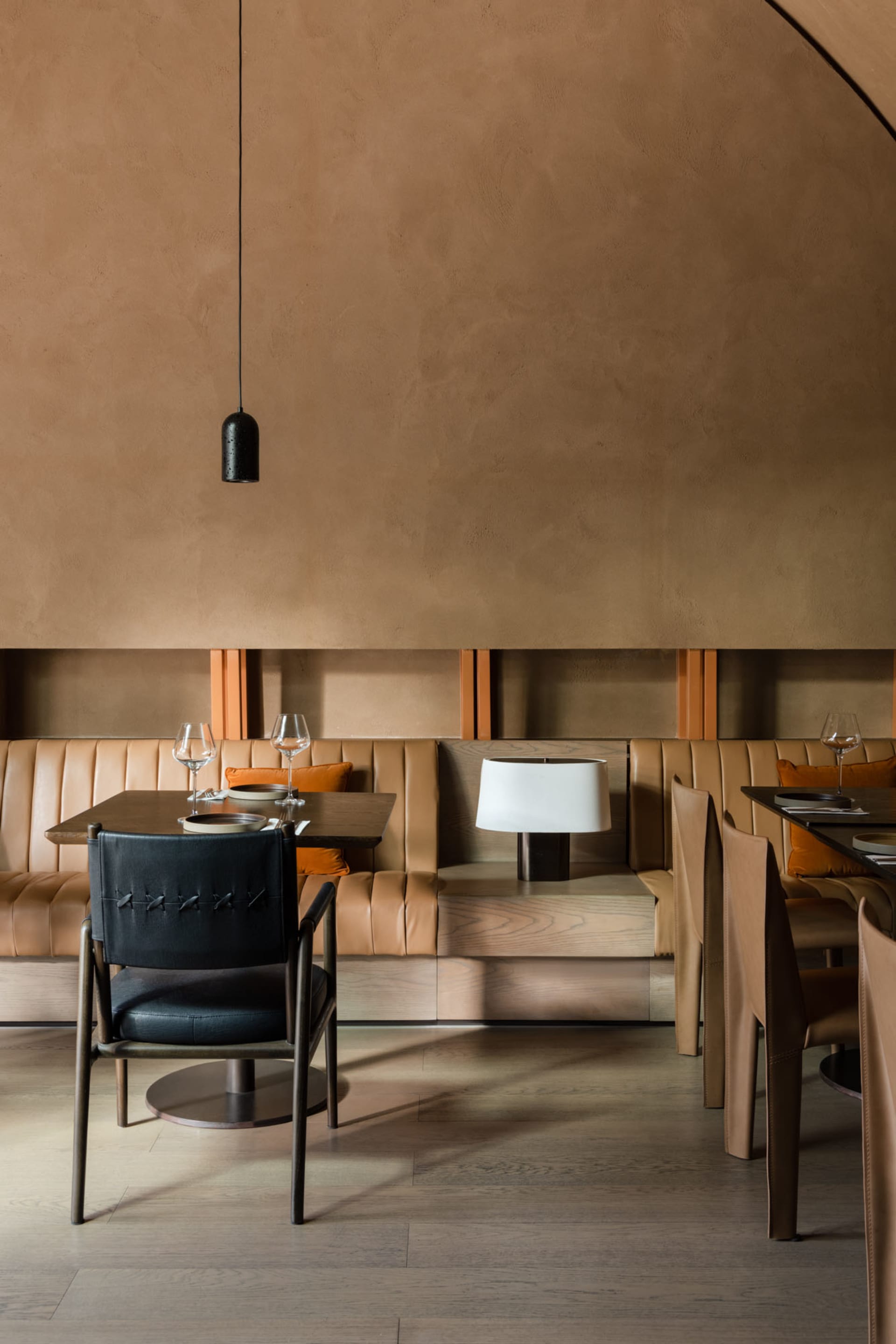 Modern restaurant table with a wooden table and leather chairs.
