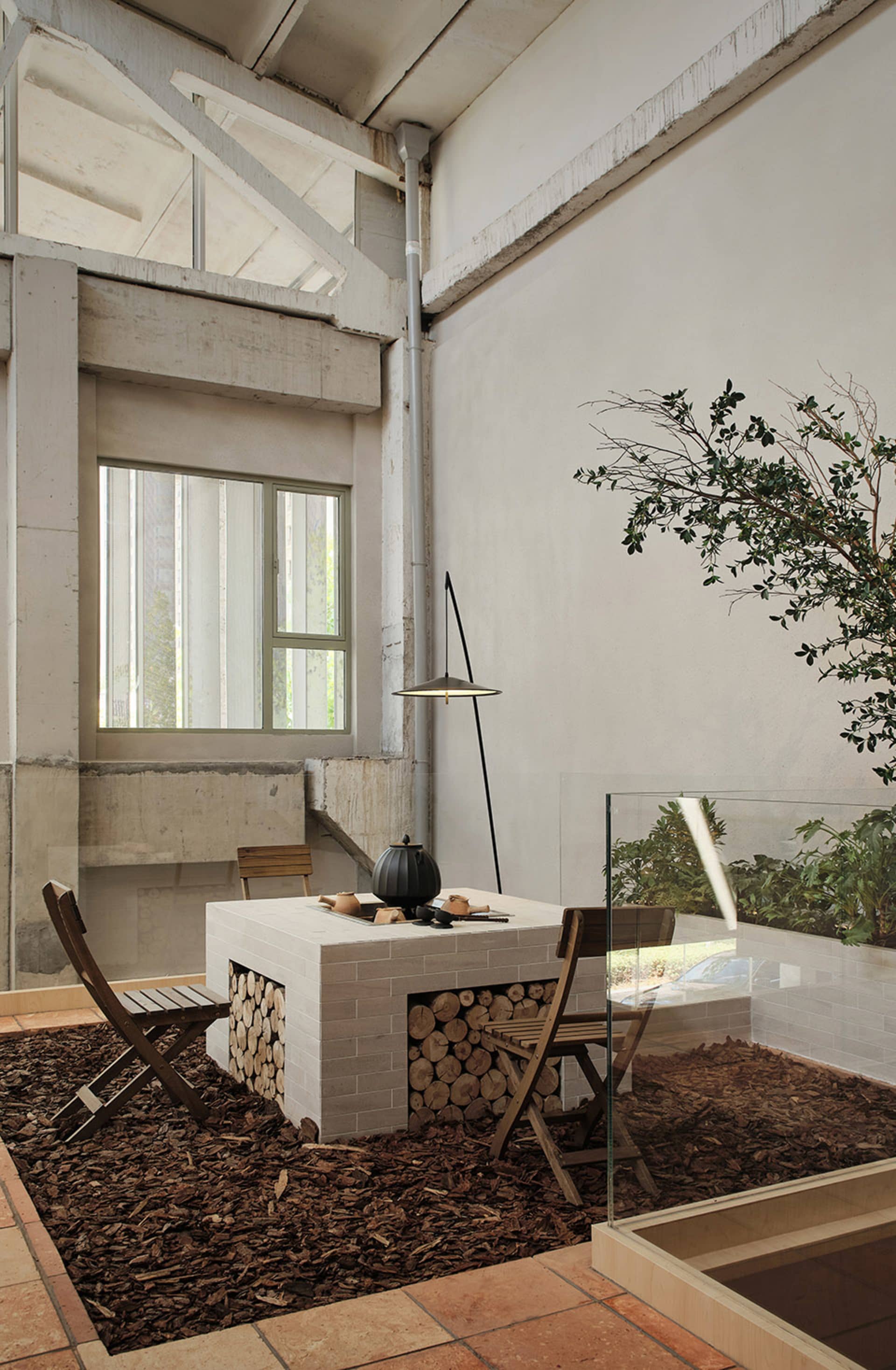 Industrial-style workspace with brick fireplace and glass enclosure