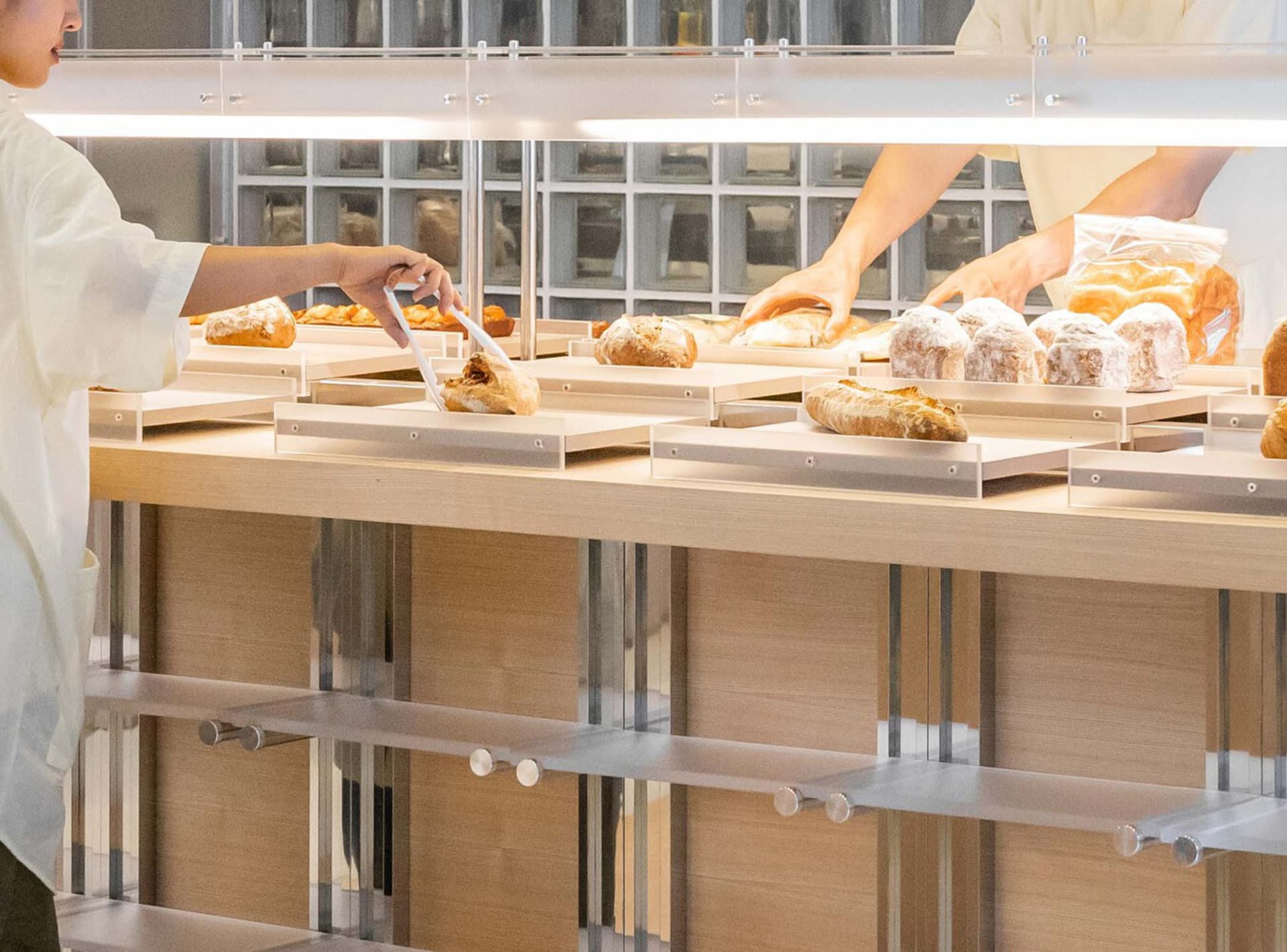 A modern bakery display counter showcasing a variety of freshly baked goods.