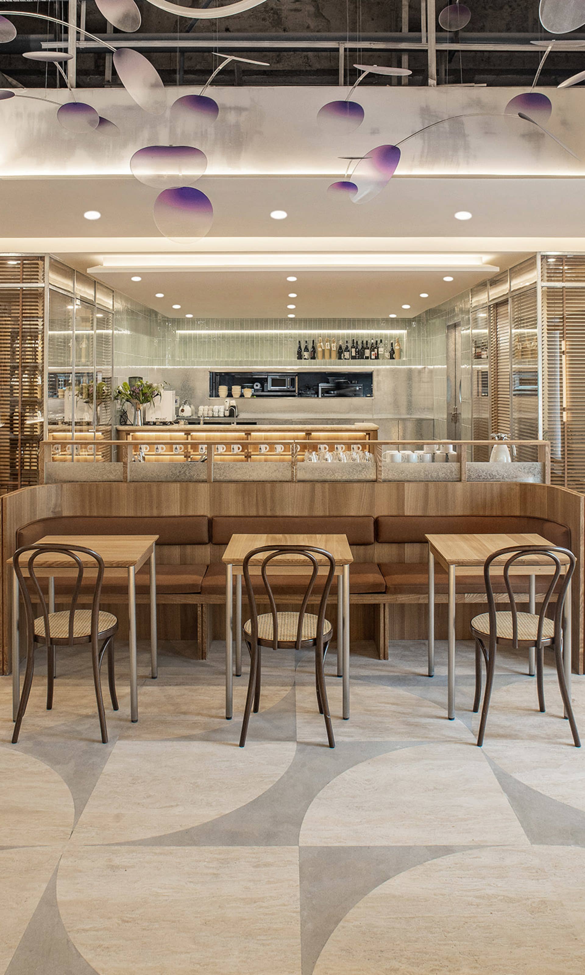 A modern cafe interior with wooden tables and chairs, minimalist decor, and a contemporary bar counter.