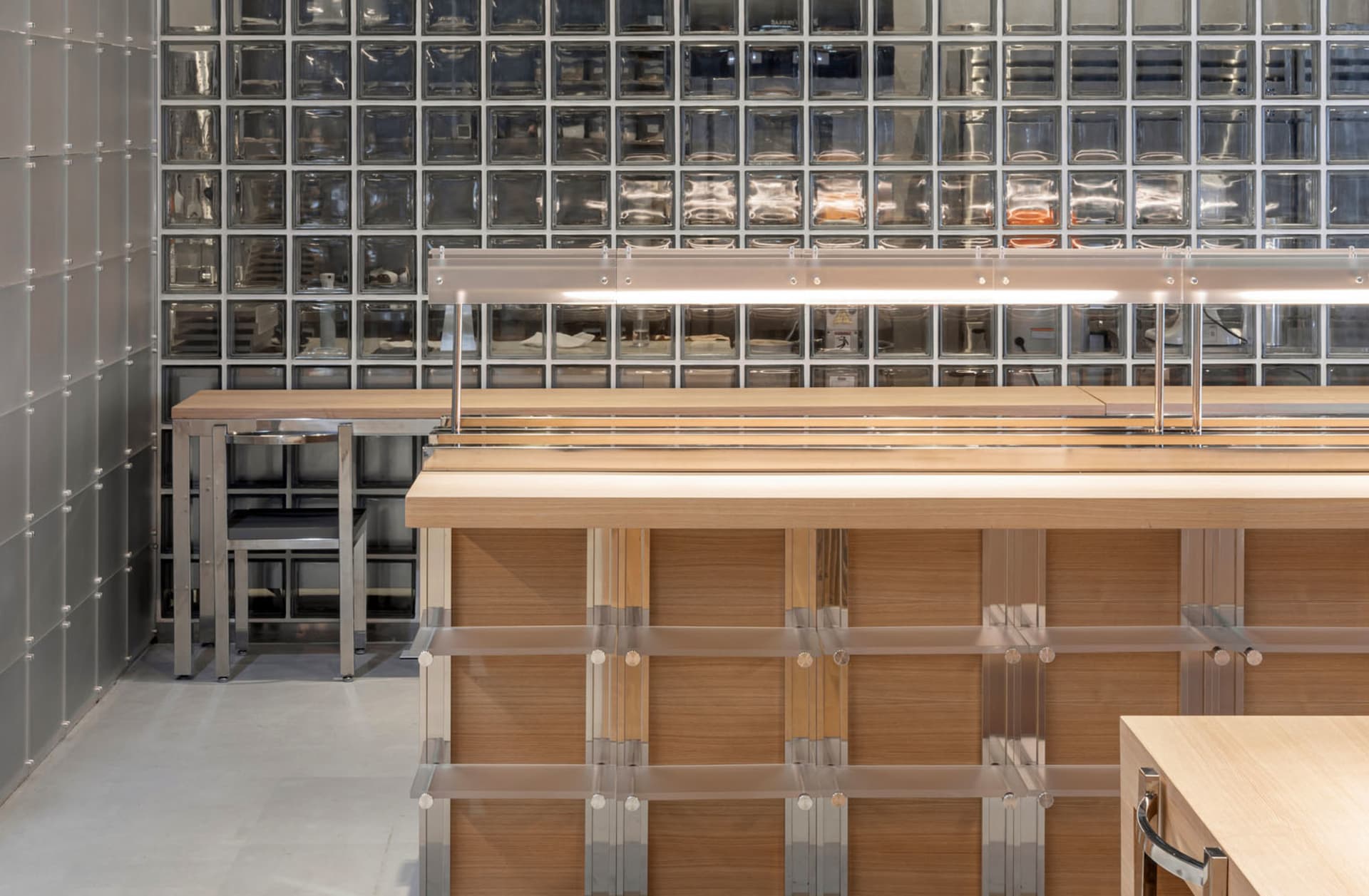 Modern industrial food court with glass block walls and wooden furniture.