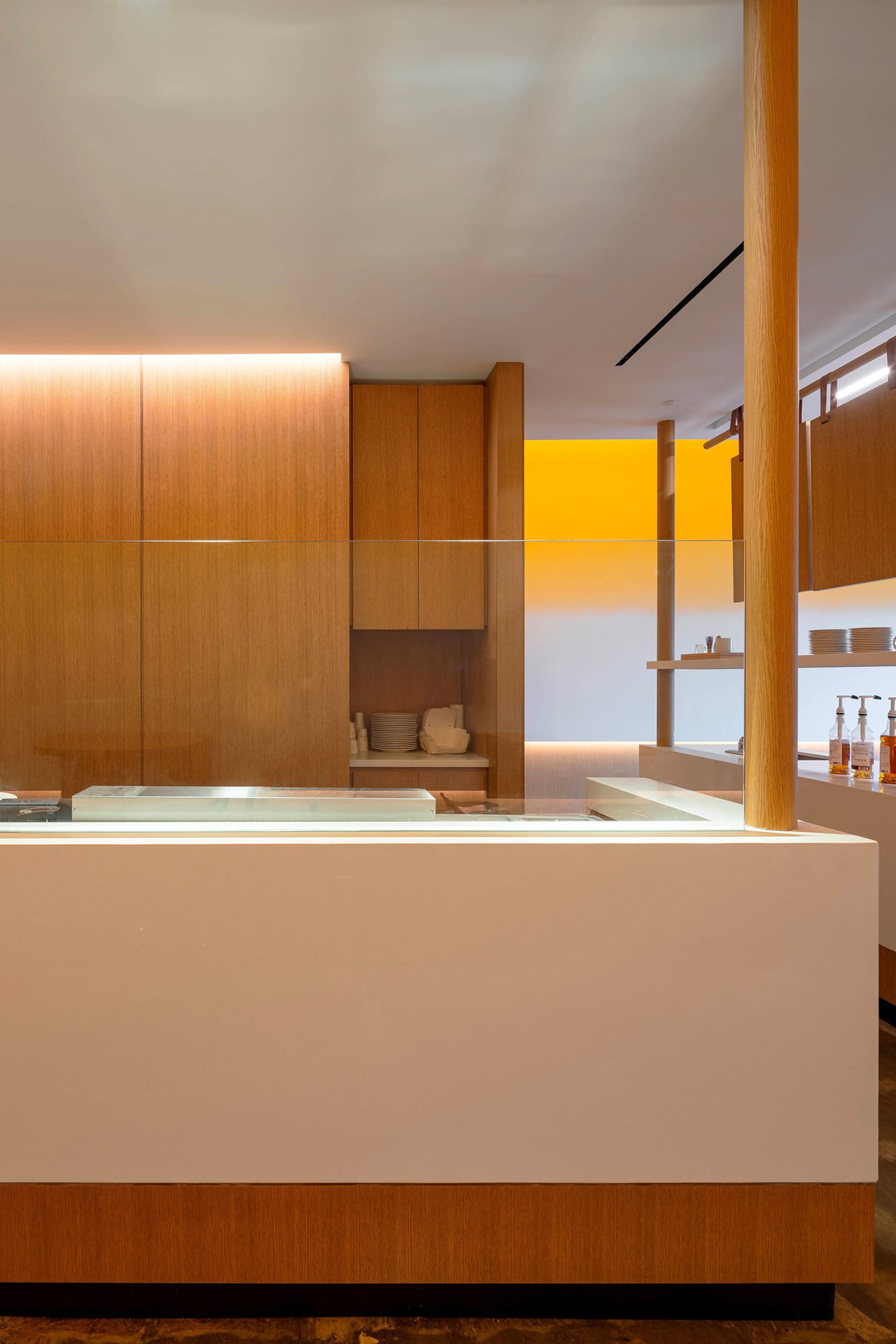Modern restaurant interior featuring a wooden counter and minimalist design elements.