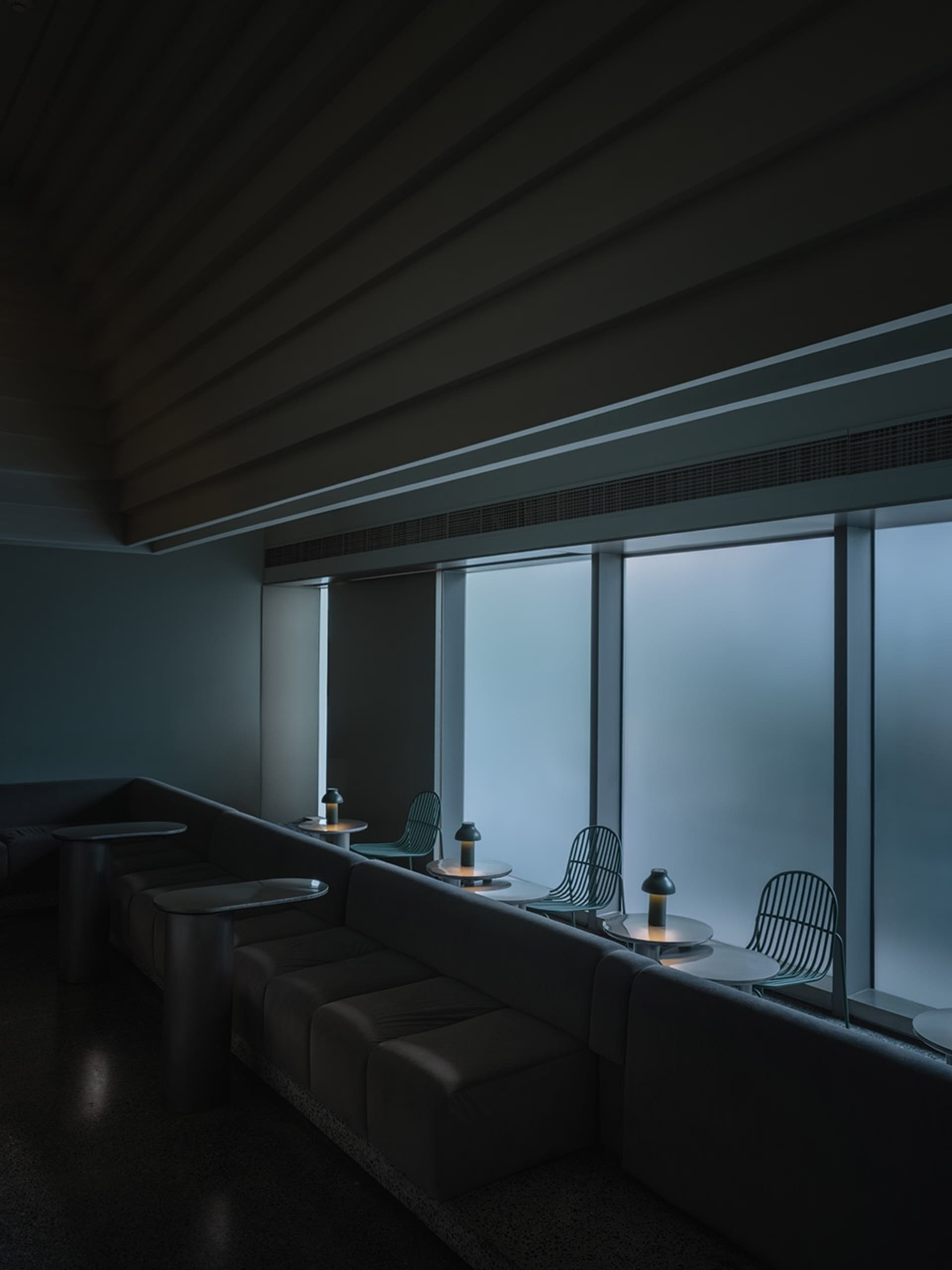 簡約餐廳室內,配有金屬家具與大型玻璃窗。