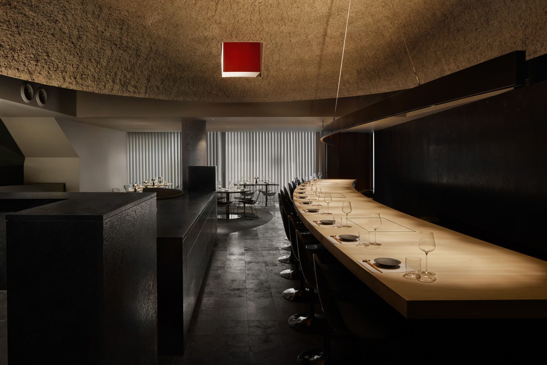 A sleek, modern restaurant interior with wooden tables and concrete accents.