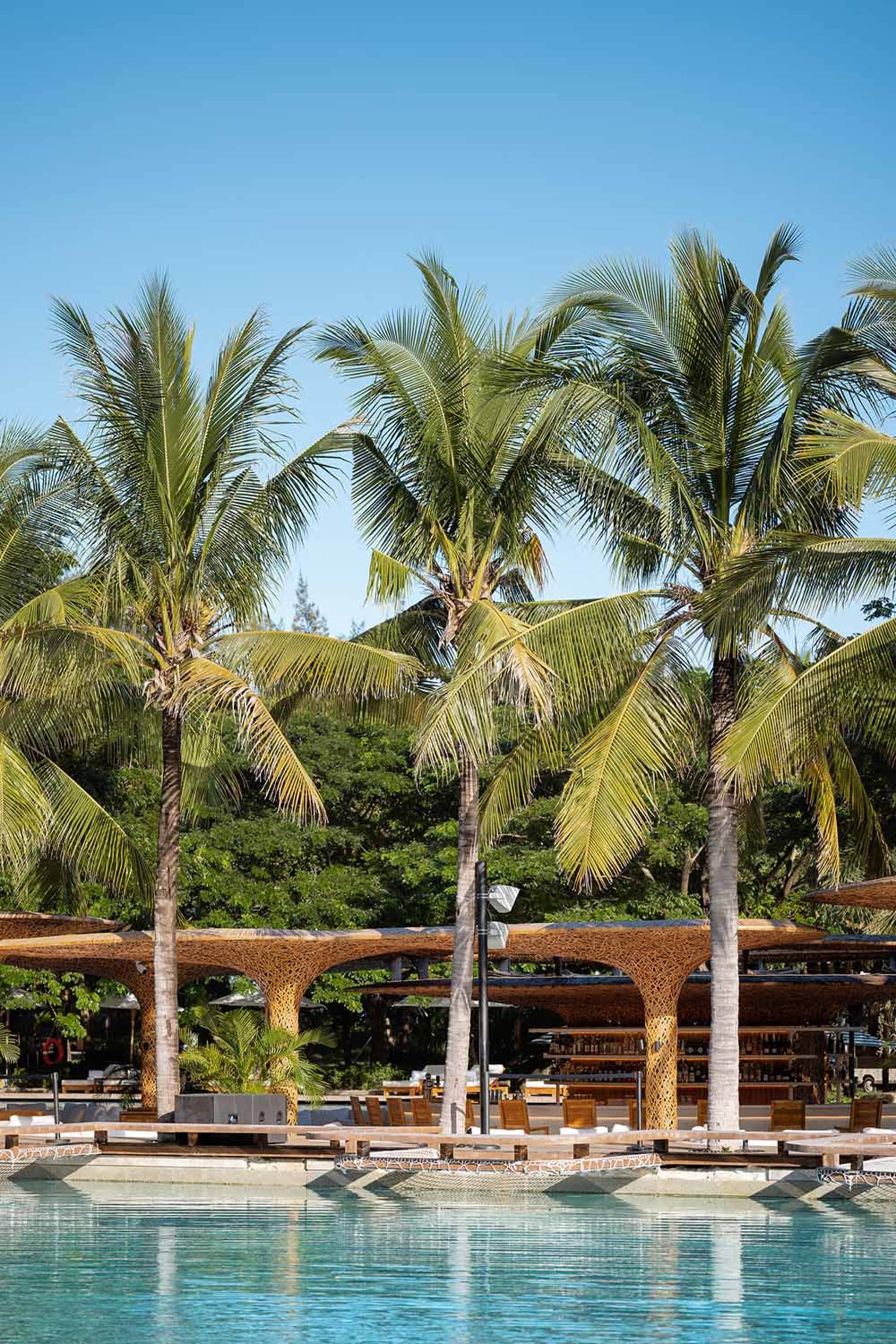 Swimming pool area with minimalist design features and wooden amenities.