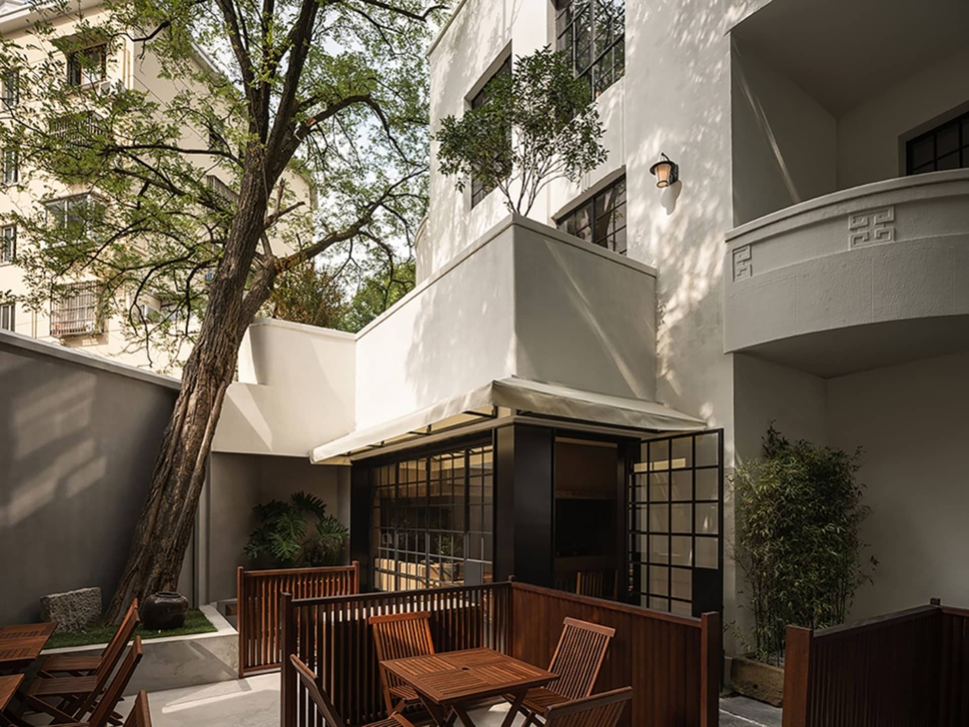 Modern residential patio with wooden furniture and plants