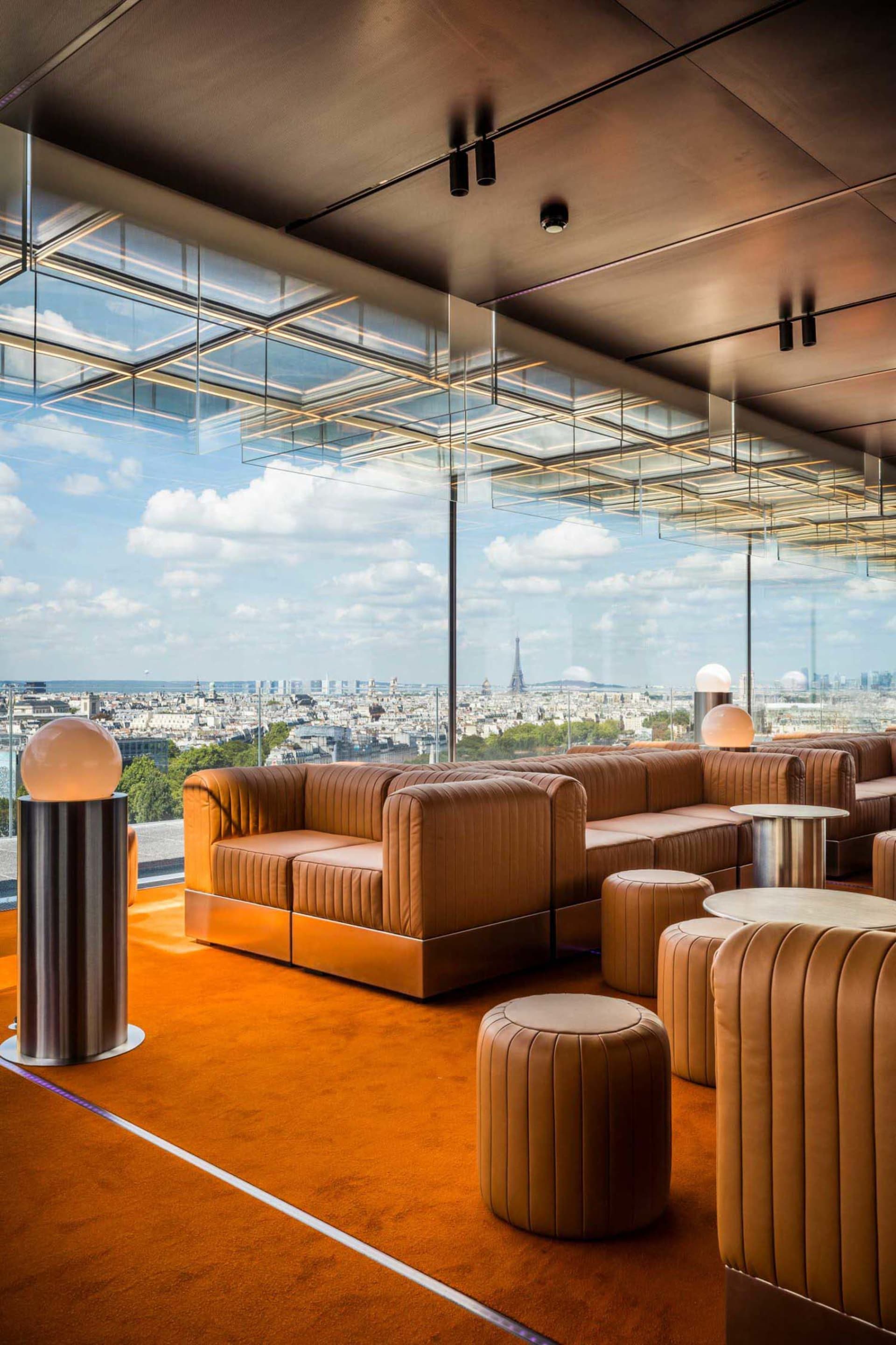 Modern rooftop bar featuring leather seating, glass ceiling, and metal accents.