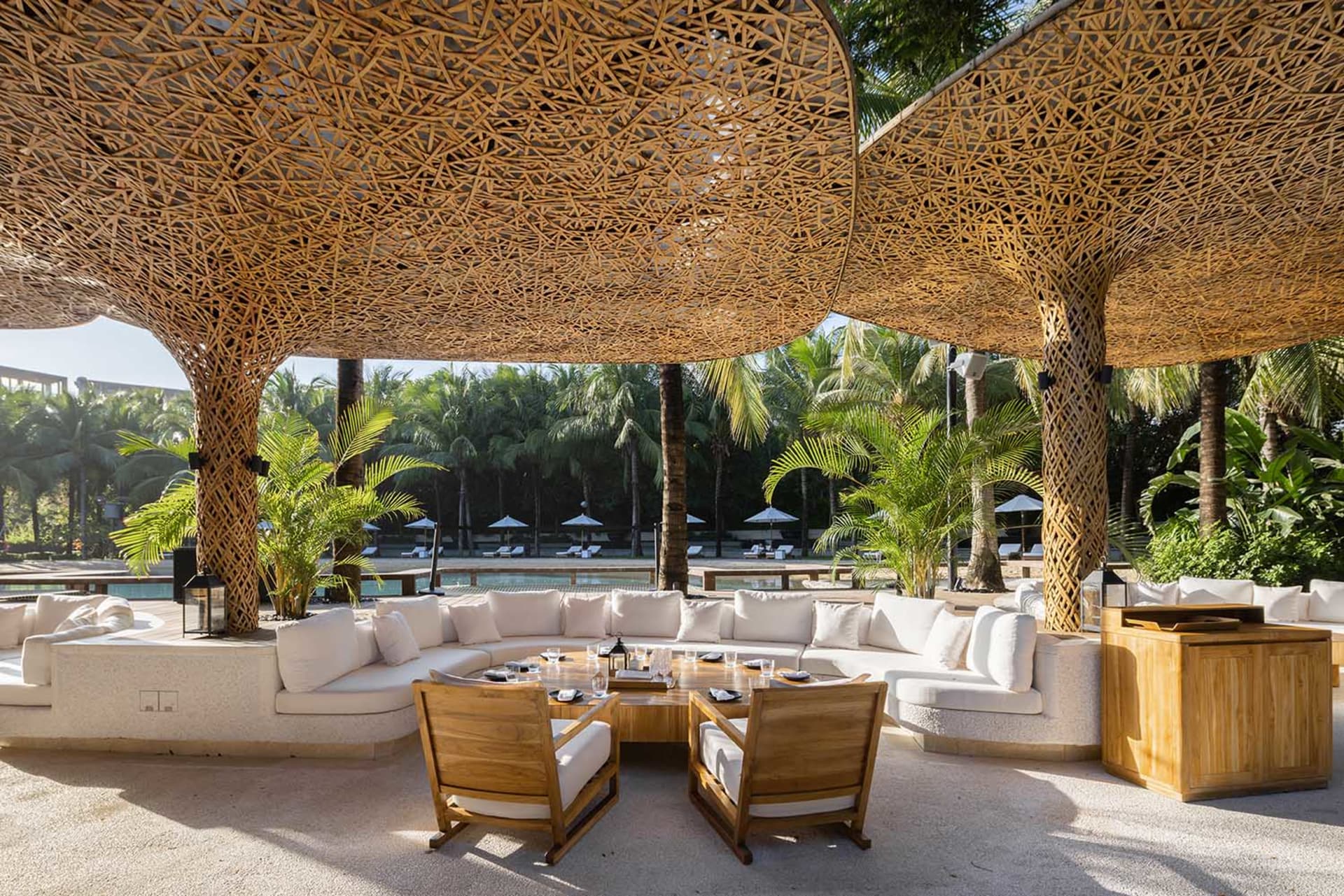 Lounge area with white cushions and wooden lattice structure