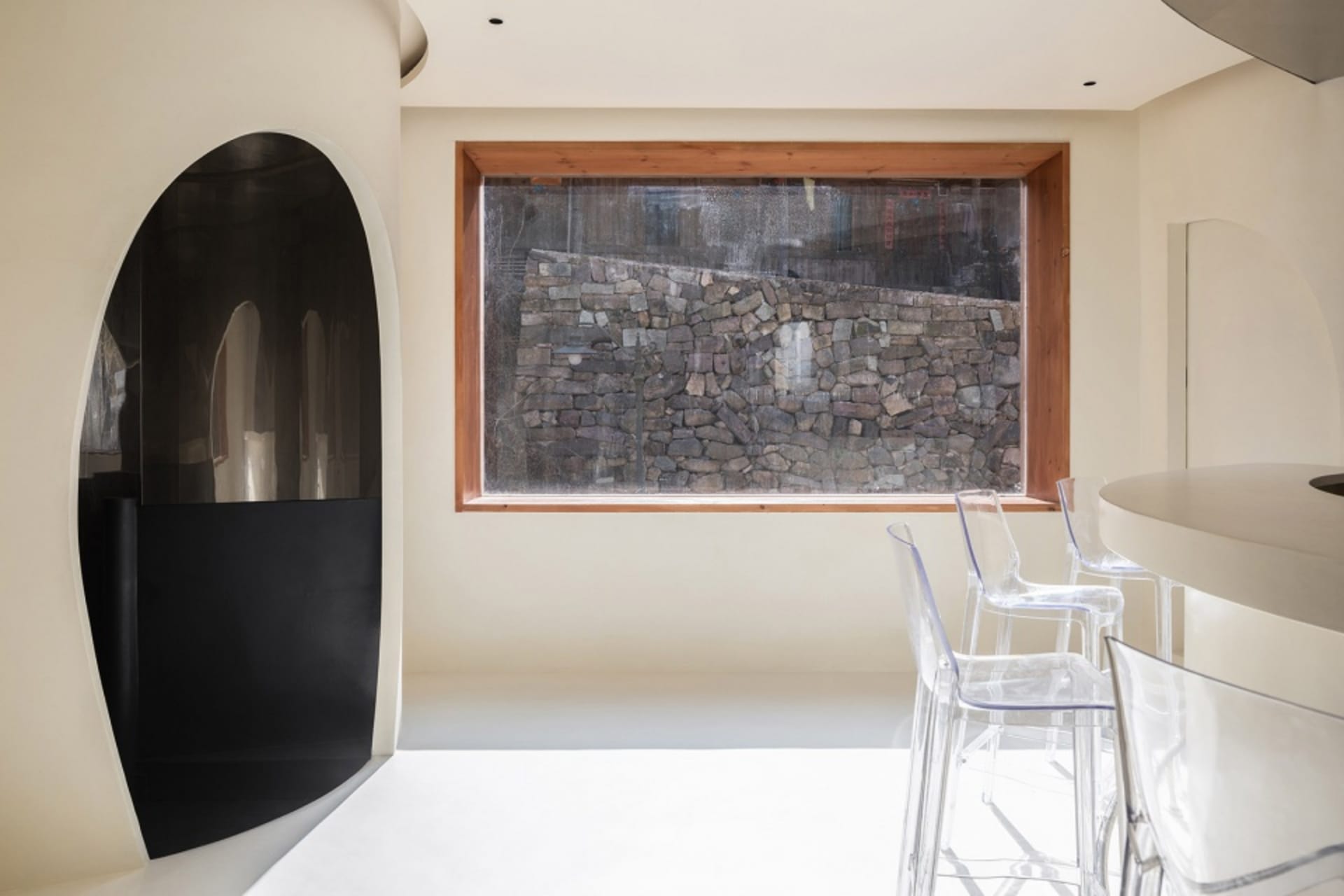 Modern minimalist interior design featuring white stone walls and glass furniture.