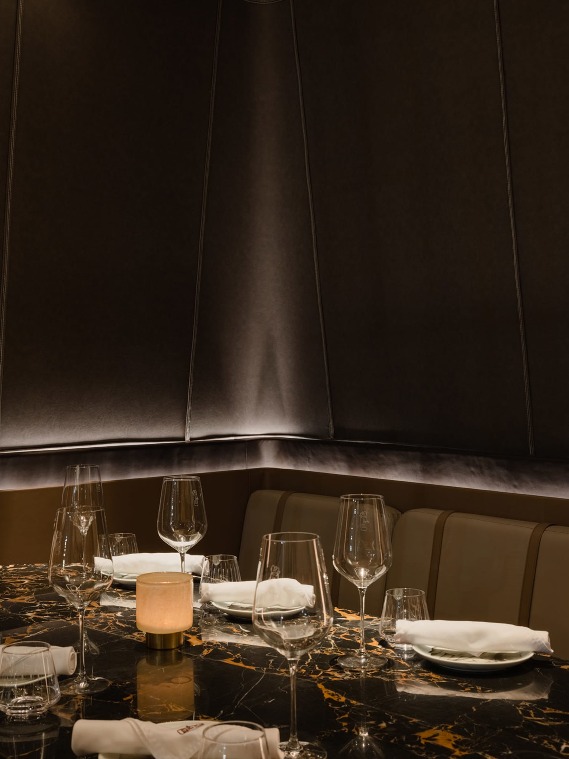 A luxury restaurant table setting with a modern design, featuring marble surfaces and elegant glassware.