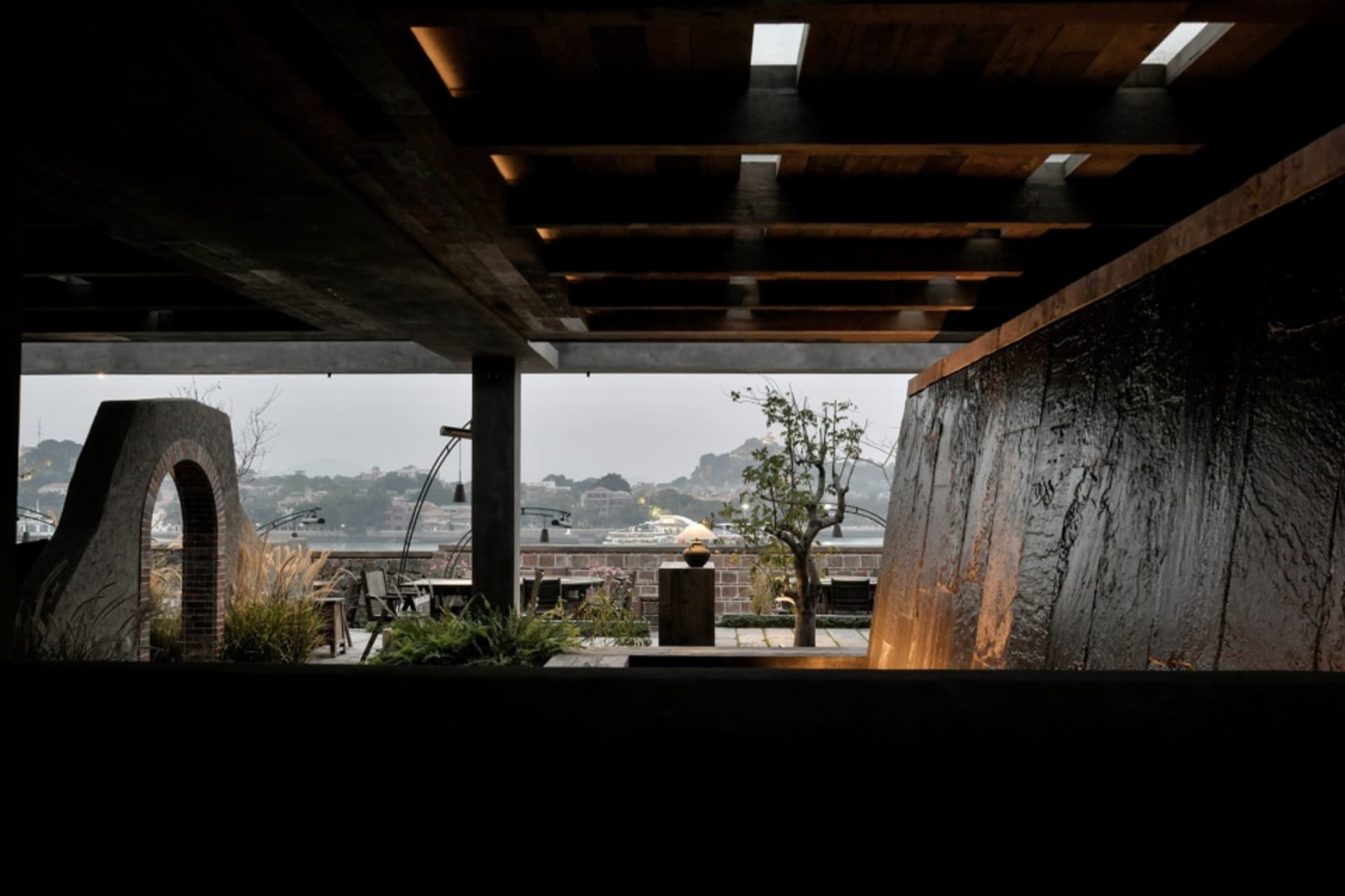A modern industrial rooftop deck garden featuring concrete and metal elements.