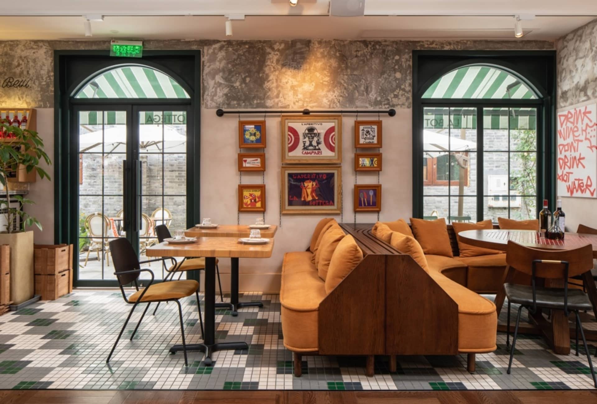 Industrial-style restaurant interior with rustic wooden furniture, mismatched table settings, and vintage decor