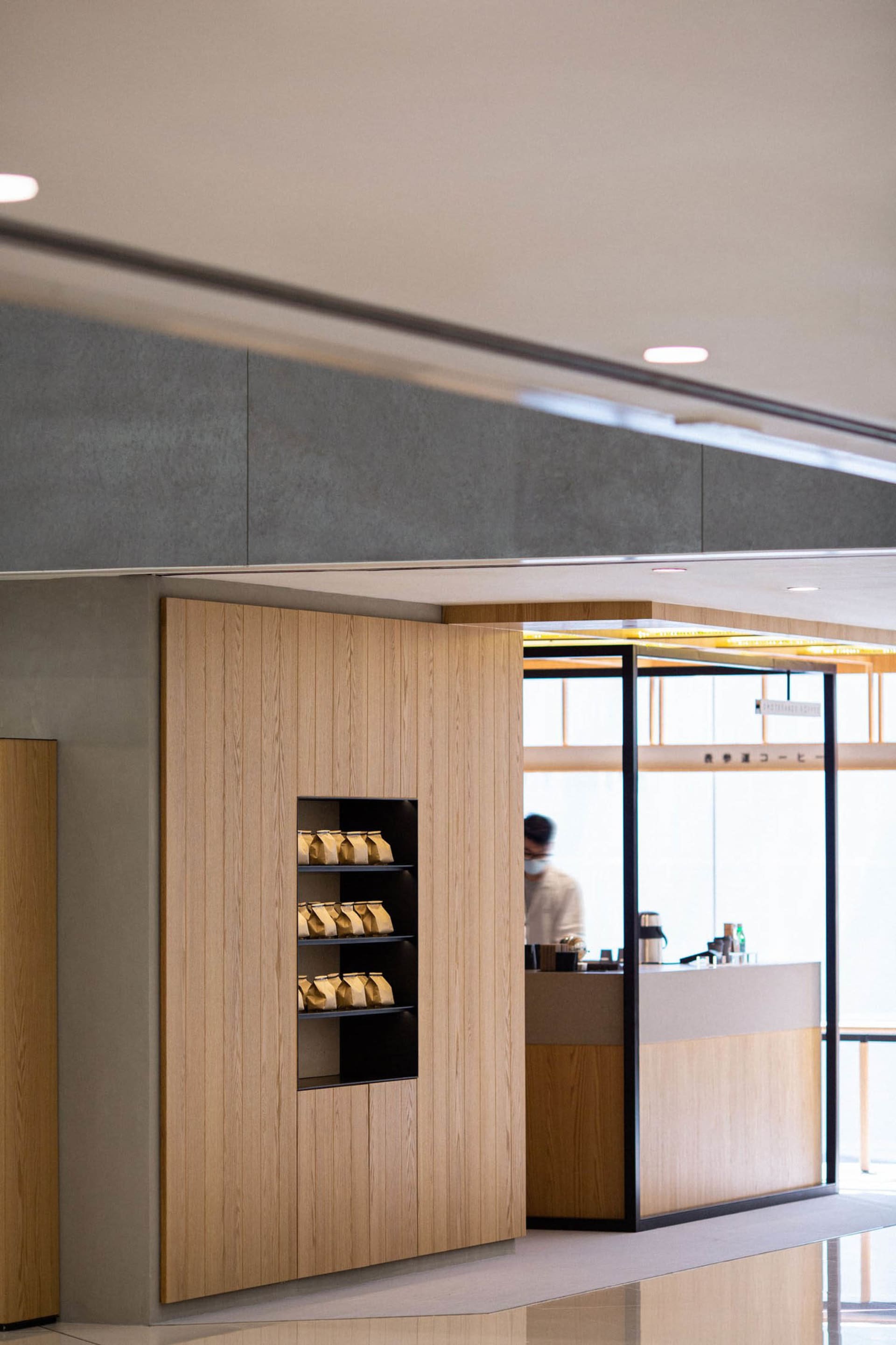 Modern coffee shop with wooden interior design elements and a coffee counter.