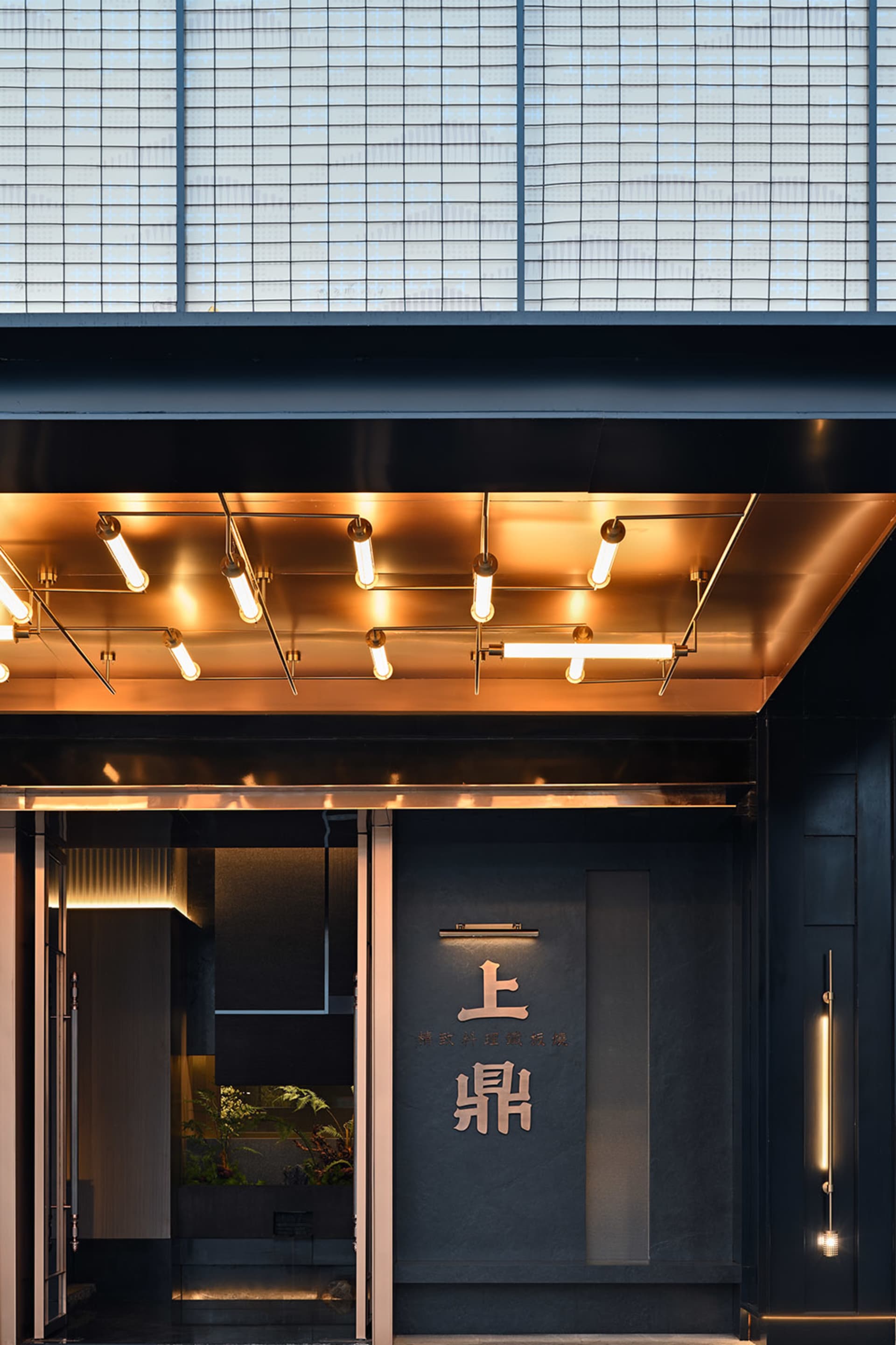 Modern entrance to a restaurant featuring metallic and glass materials.