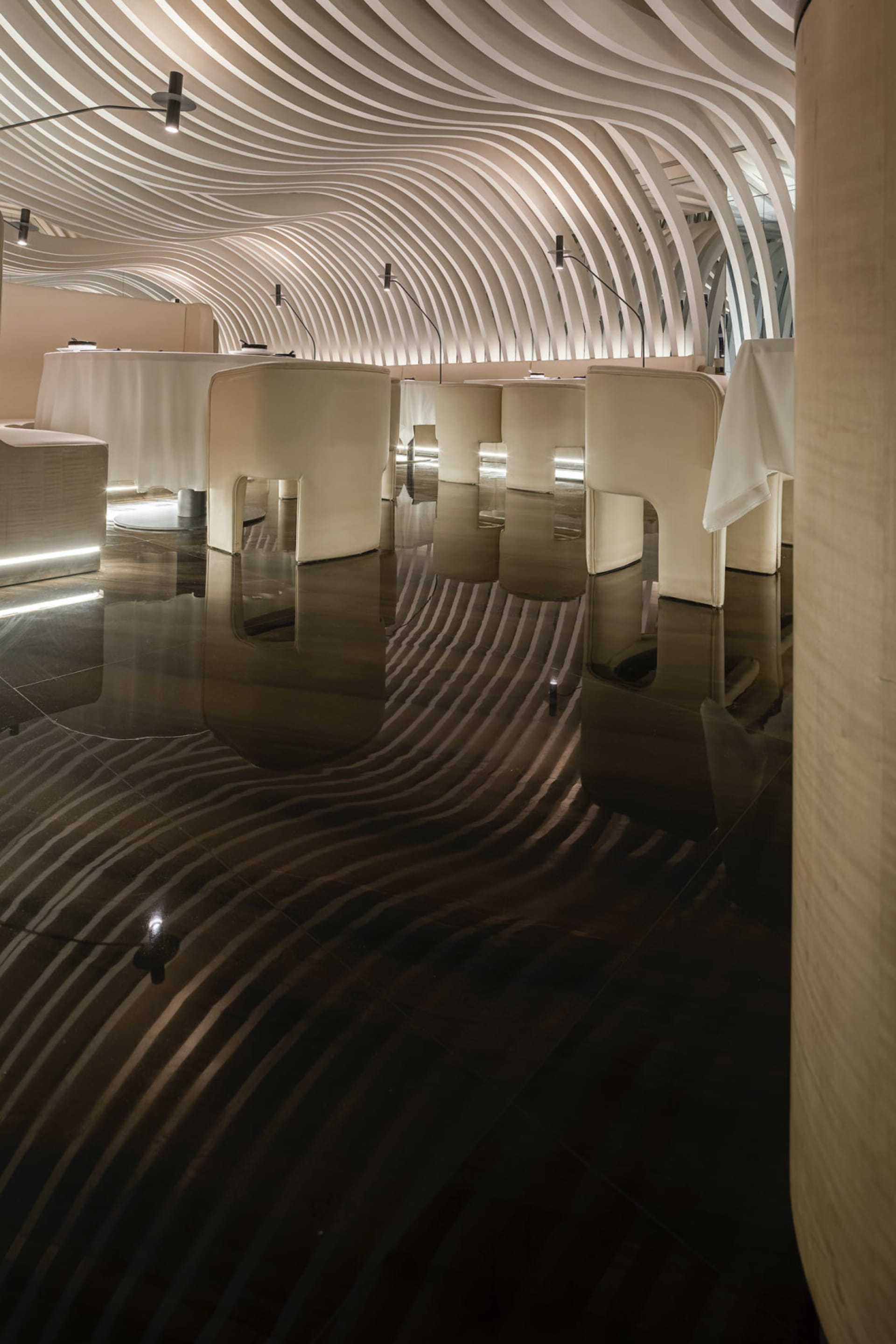 A modern interior space with concrete walls, illuminated by soft, warm lighting.