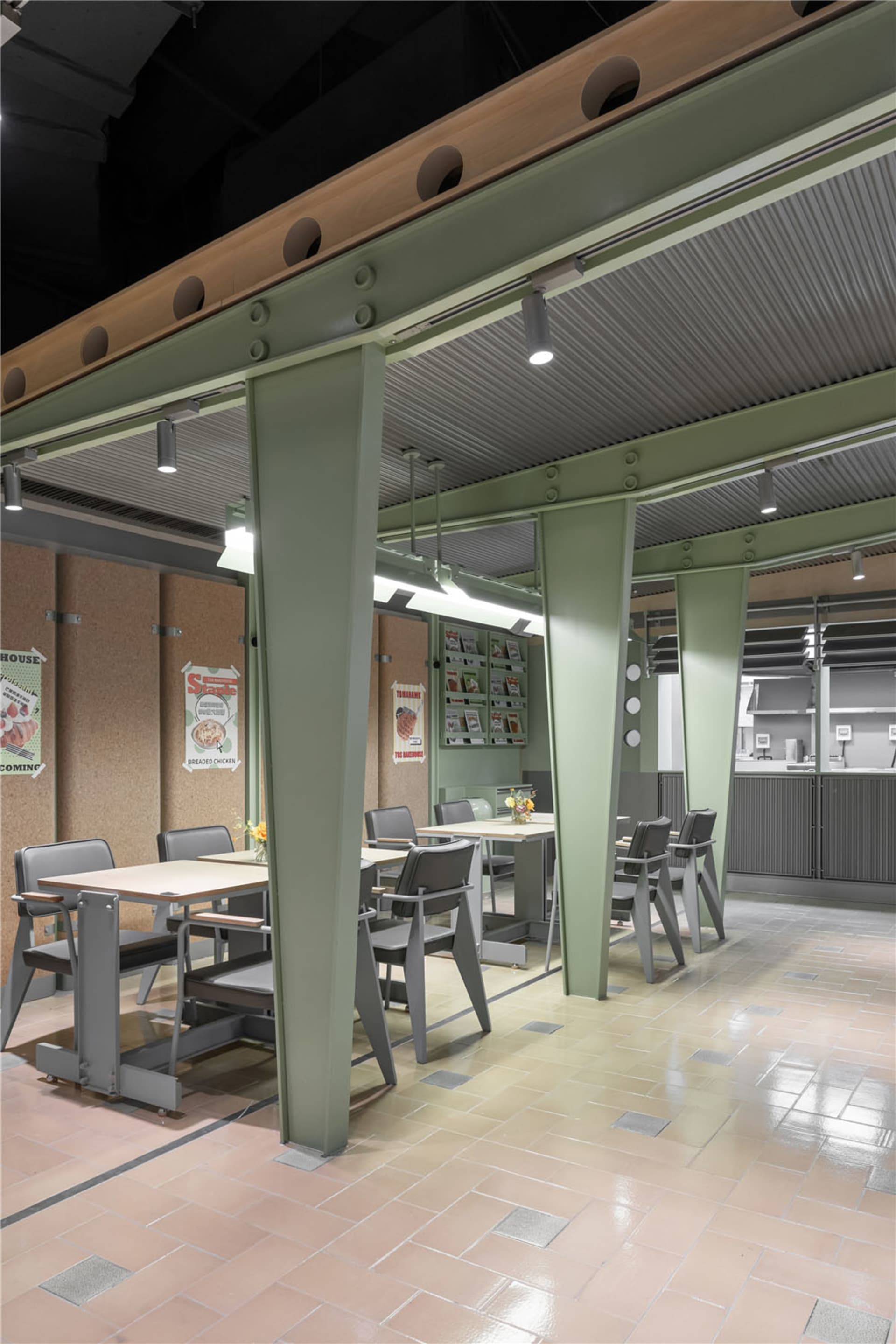 工業風餐廳室內空間,設有金屬柱、軟木板牆面與木製餐桌。