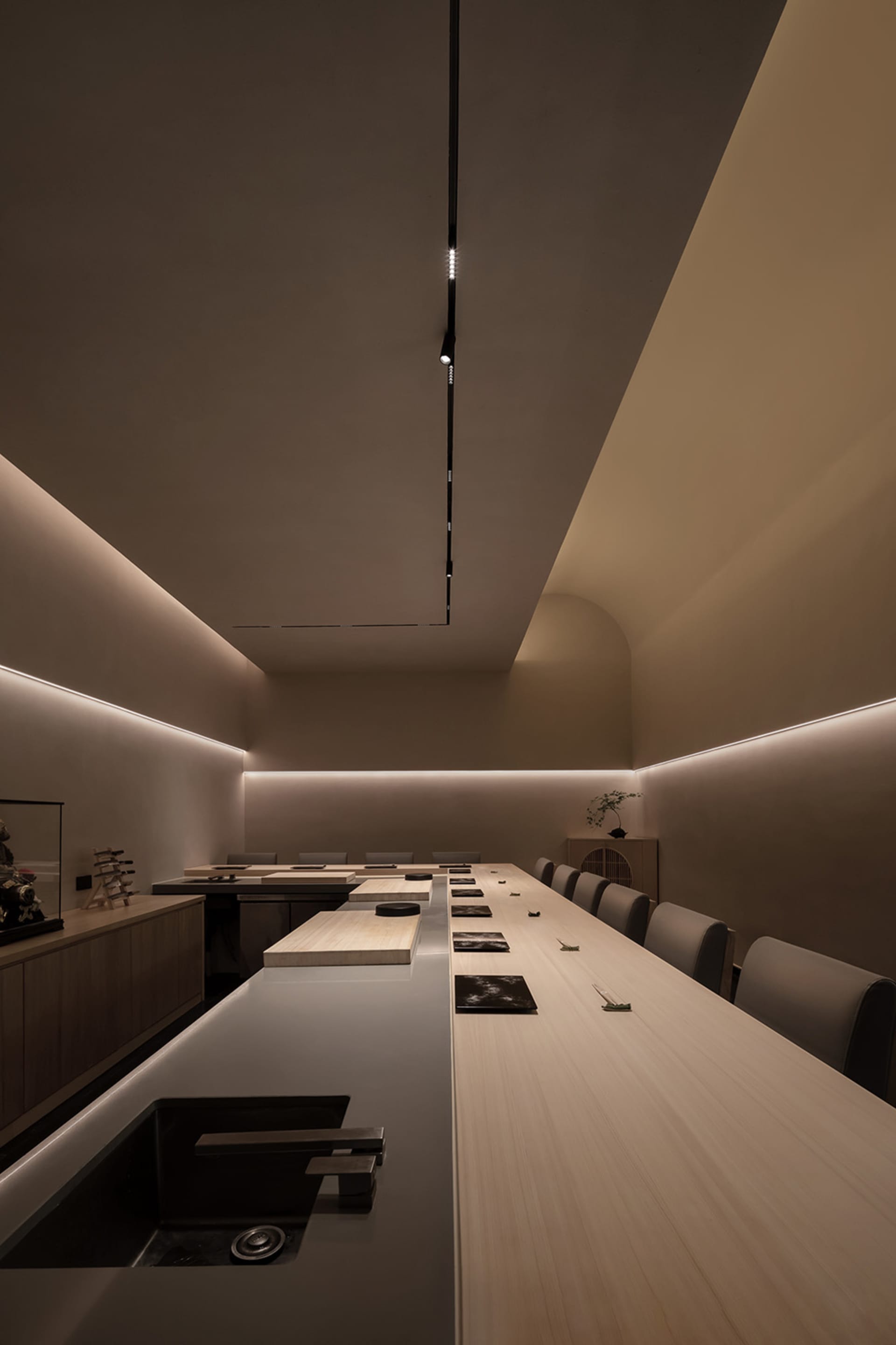 Modern restaurant interior with wooden tables, concrete walls, and minimalist design.