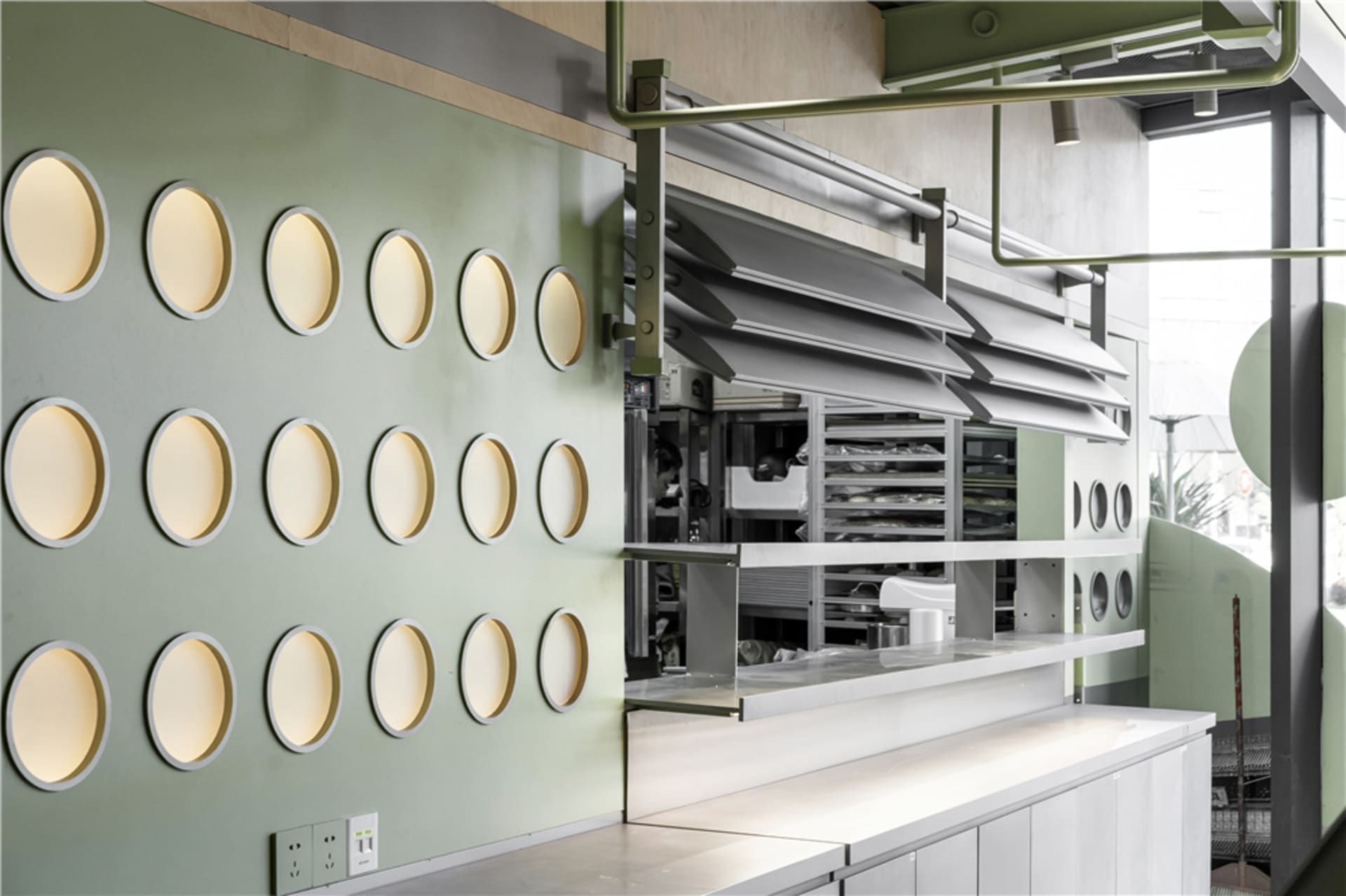 The interior of a modern restaurant featuring a wall with circular glass panels.