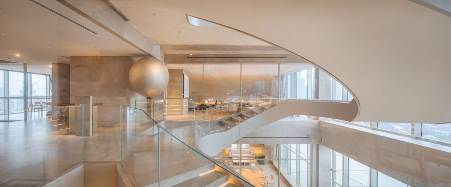 A modern corporate lobby featuring glass walls and marble flooring.