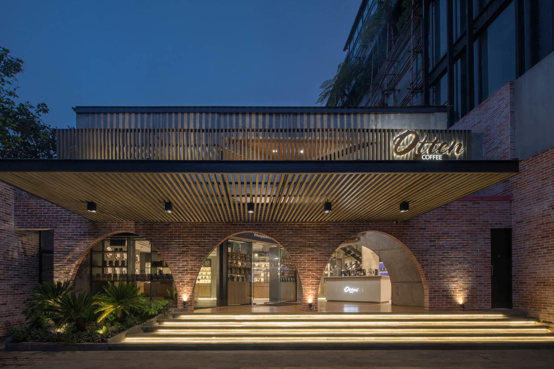 Modern coffee shop entrance with brick exterior and archways.