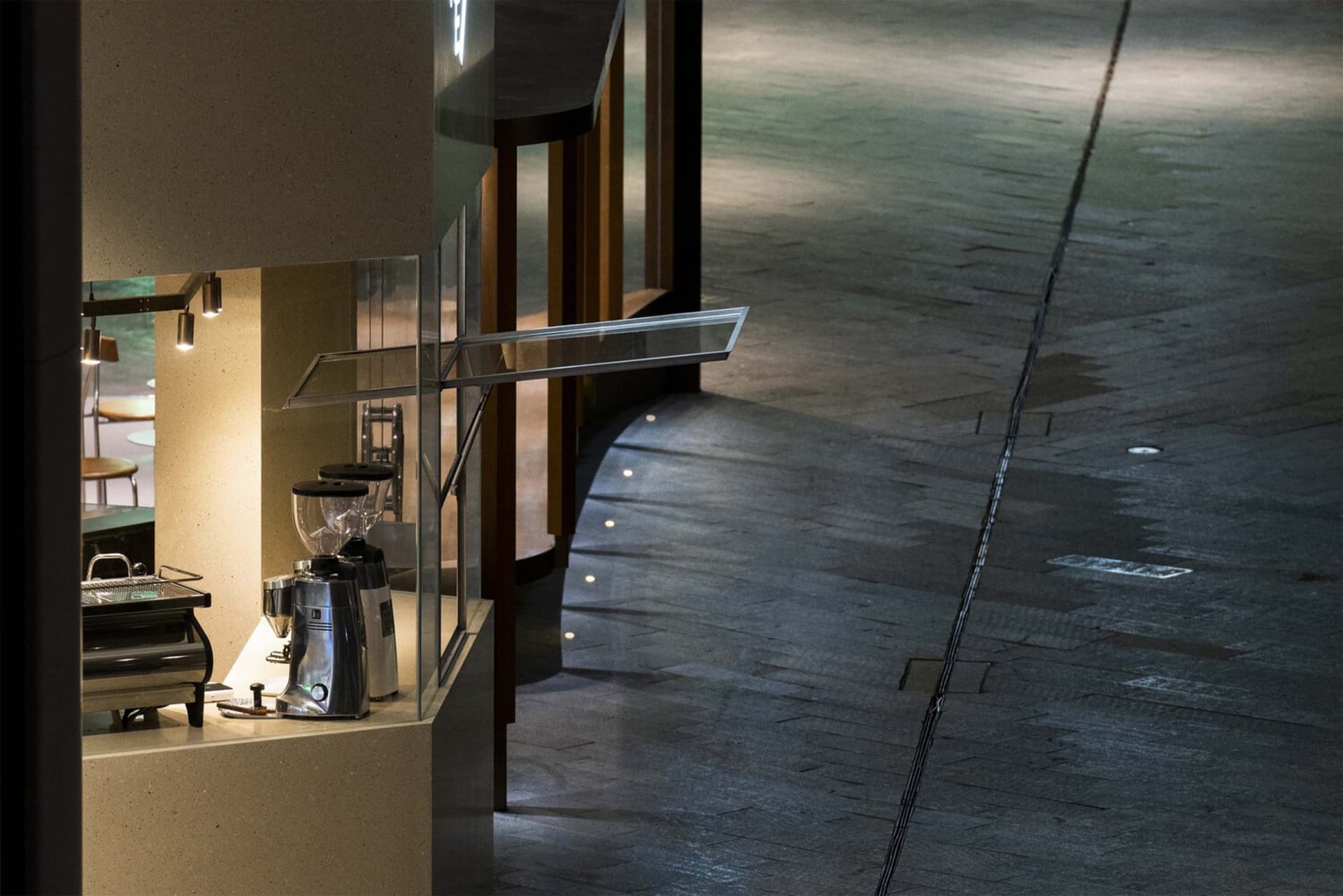 A minimalist coffee shop interior featuring metallic finishes and sleek design elements.