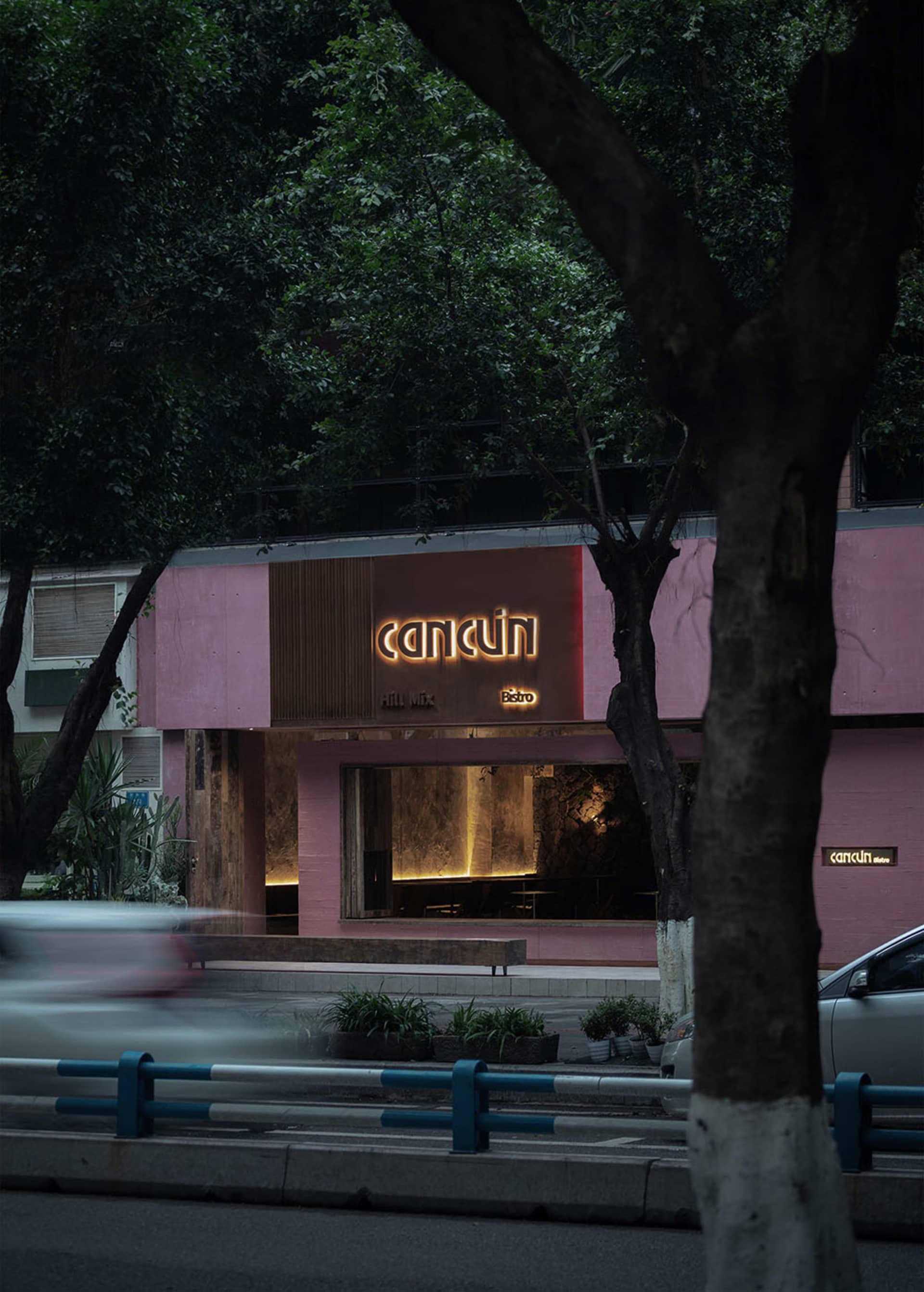 夜晚粉紅色店面,招牌發出「Cancún」字樣的光芒。