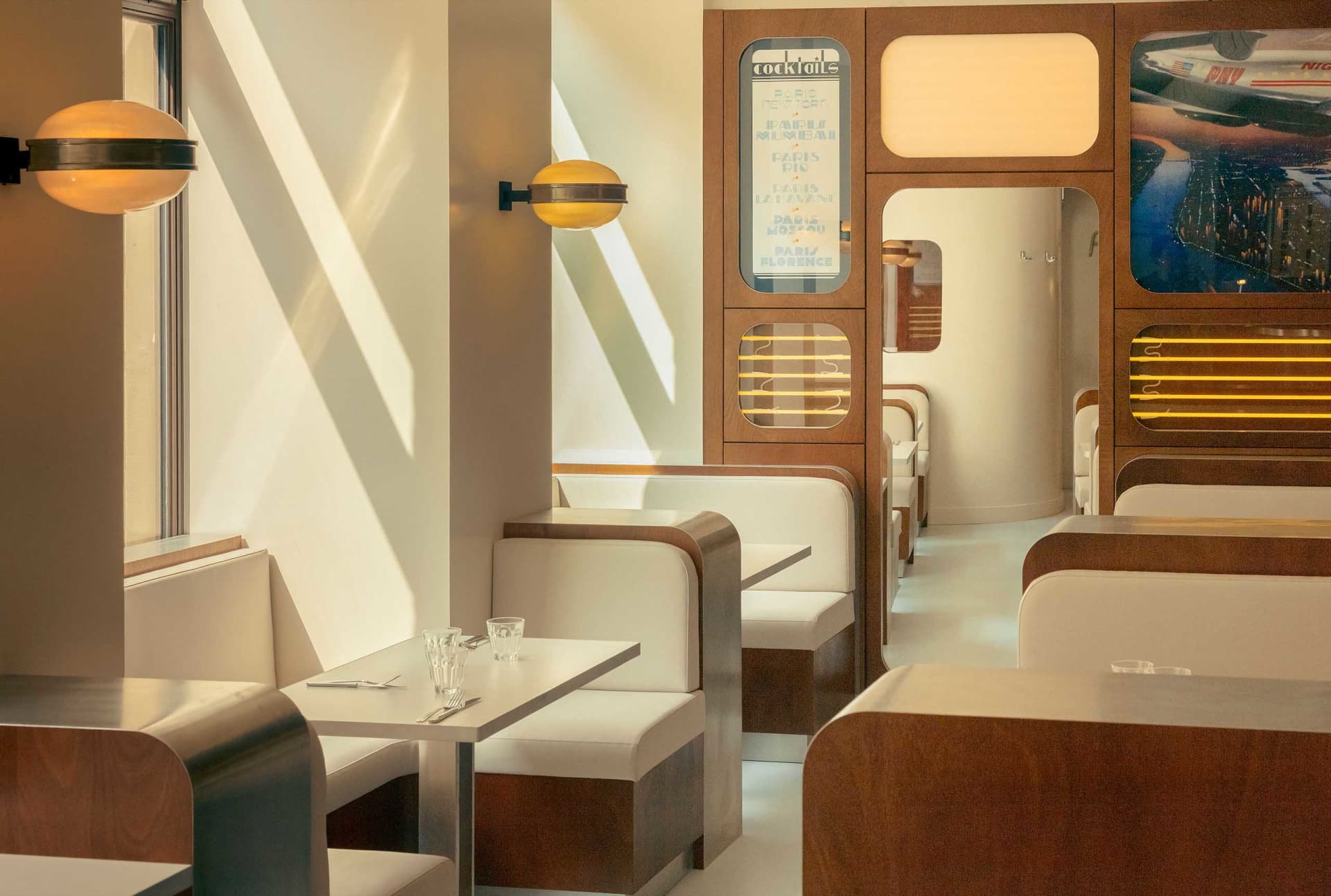 Modern restaurant interior with sleek, white seating and wooden accents.