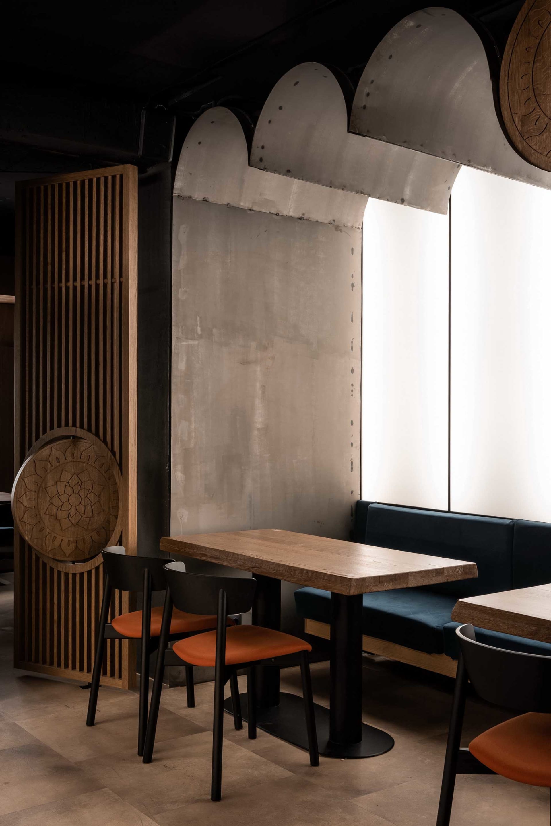現代餐廳座位區，搭配木質餐桌、混凝土牆面及金屬點綴。