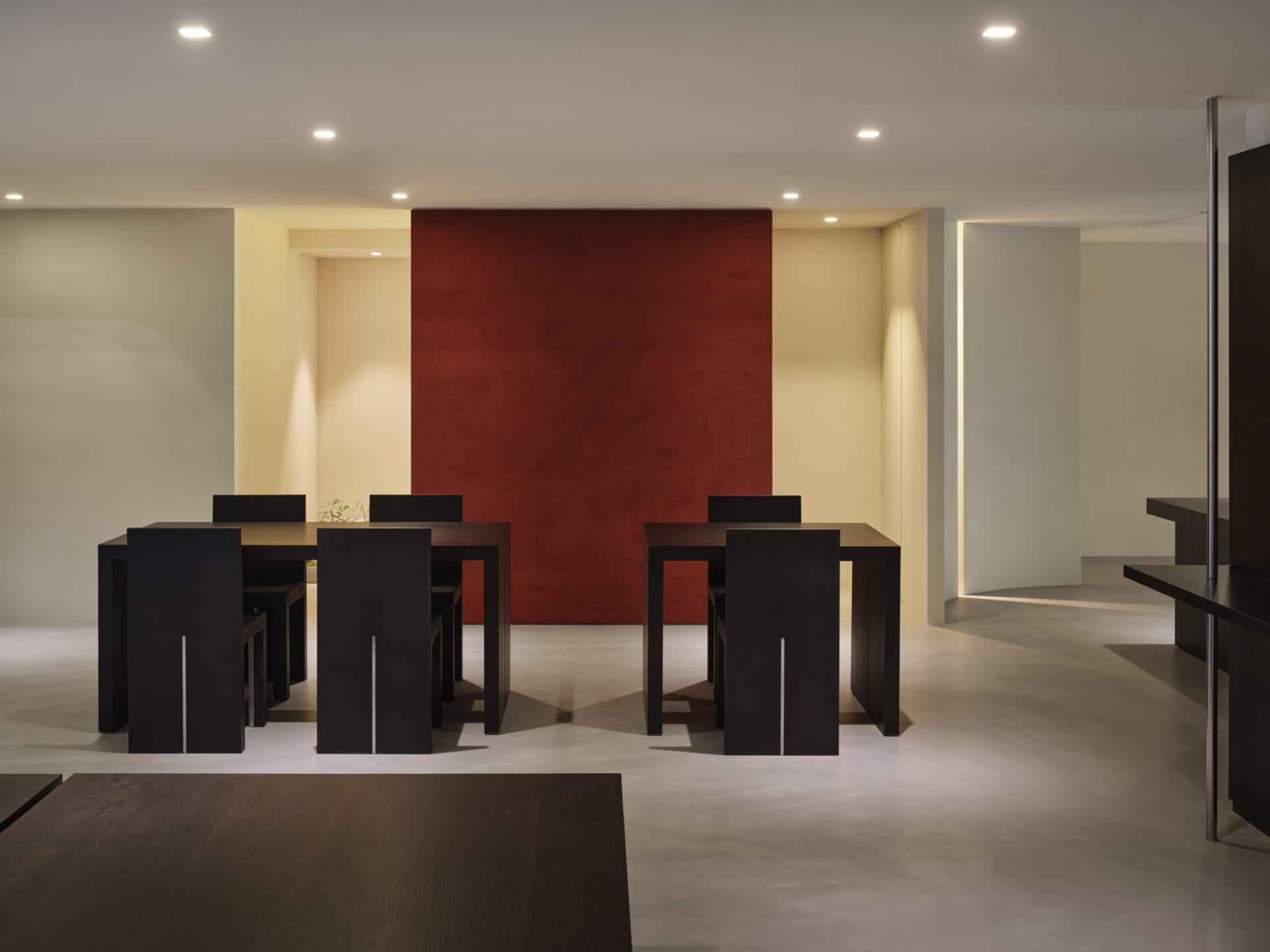 Modern dining room featuring dark wood furniture and red accent wall