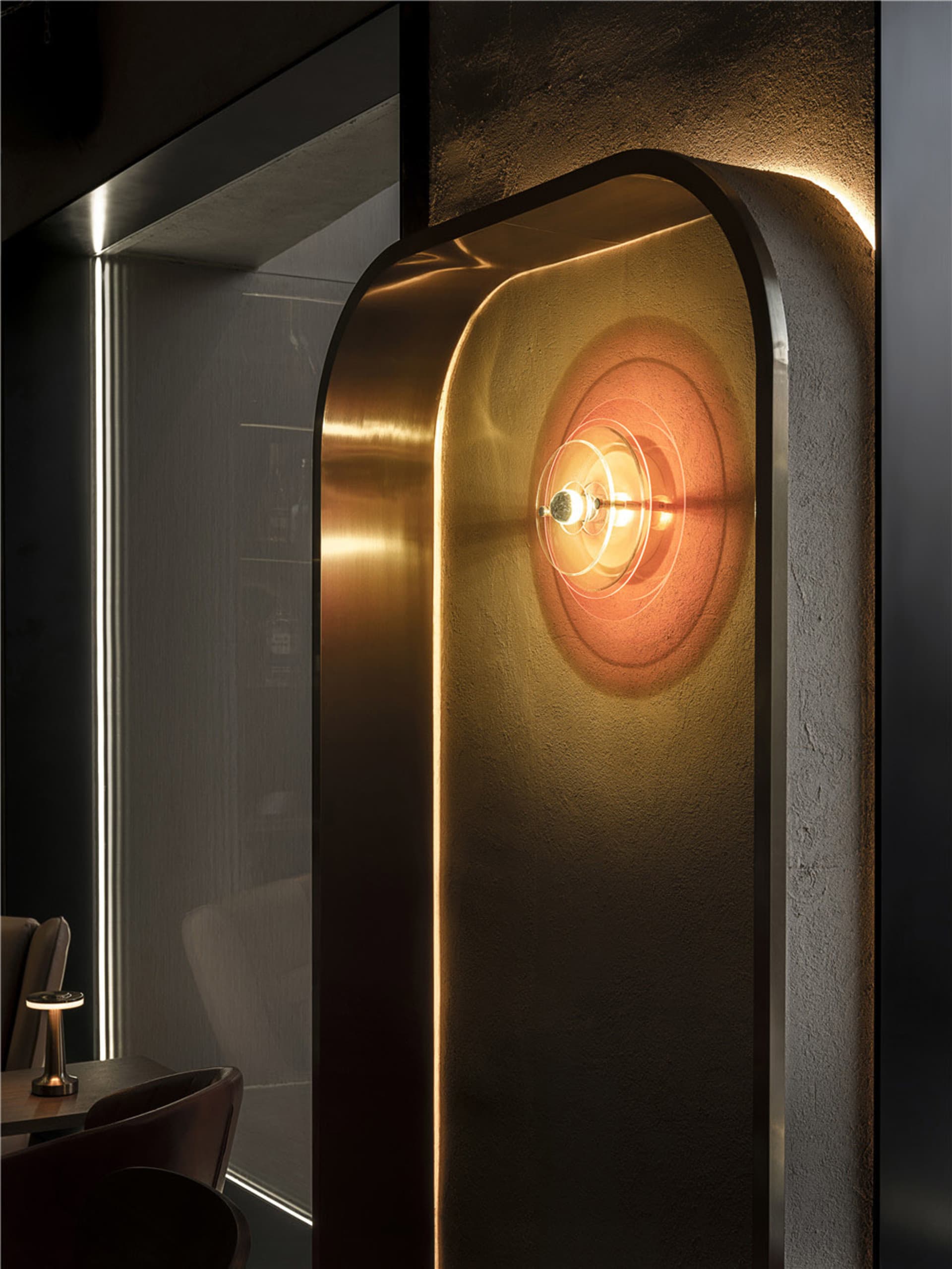 A modern office space features brass, glass, and concrete materials.