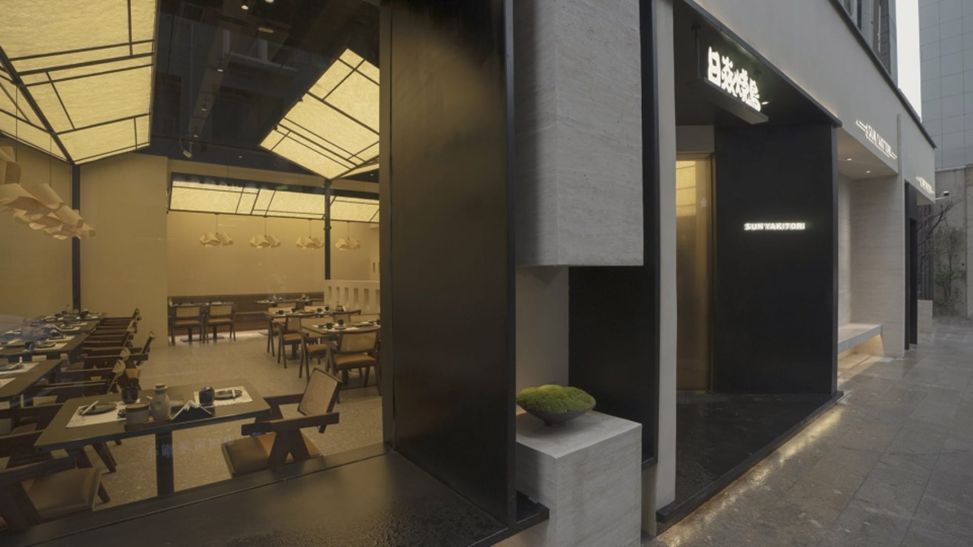 Modern restaurant interior featuring concrete, wood, and glass materials