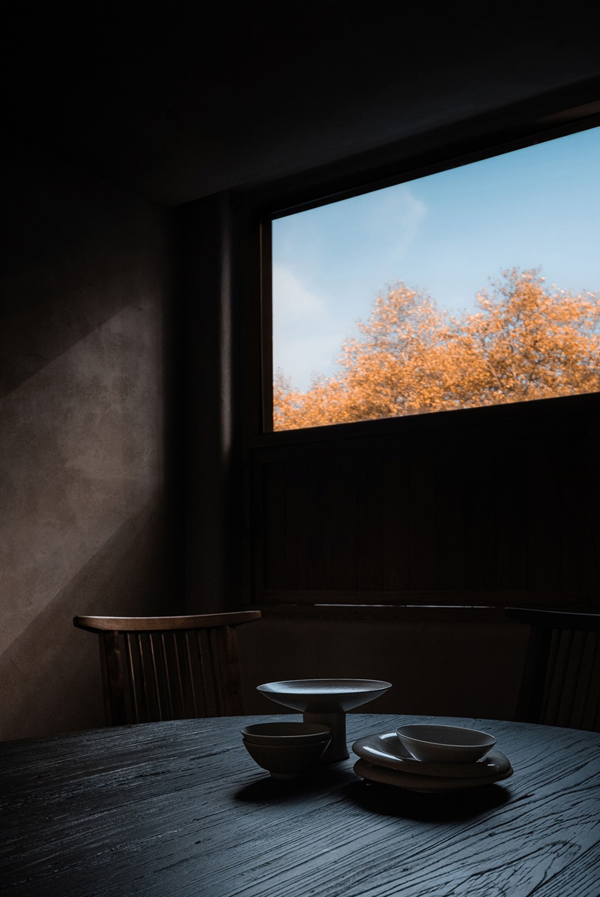 Modern dining room featuring wood table and chairs with a view outside.