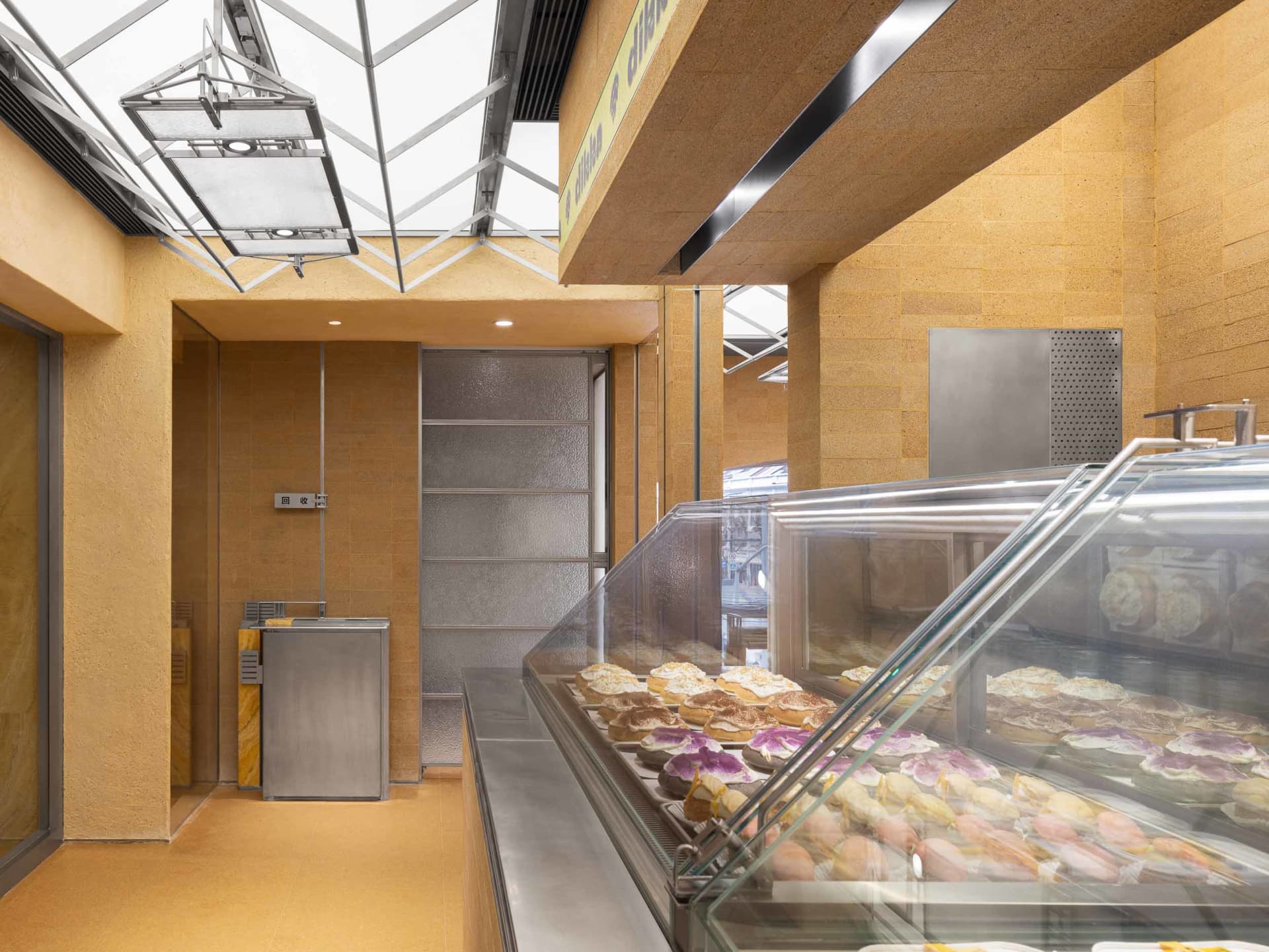 Modern bakery interior with concrete paneling and skylights