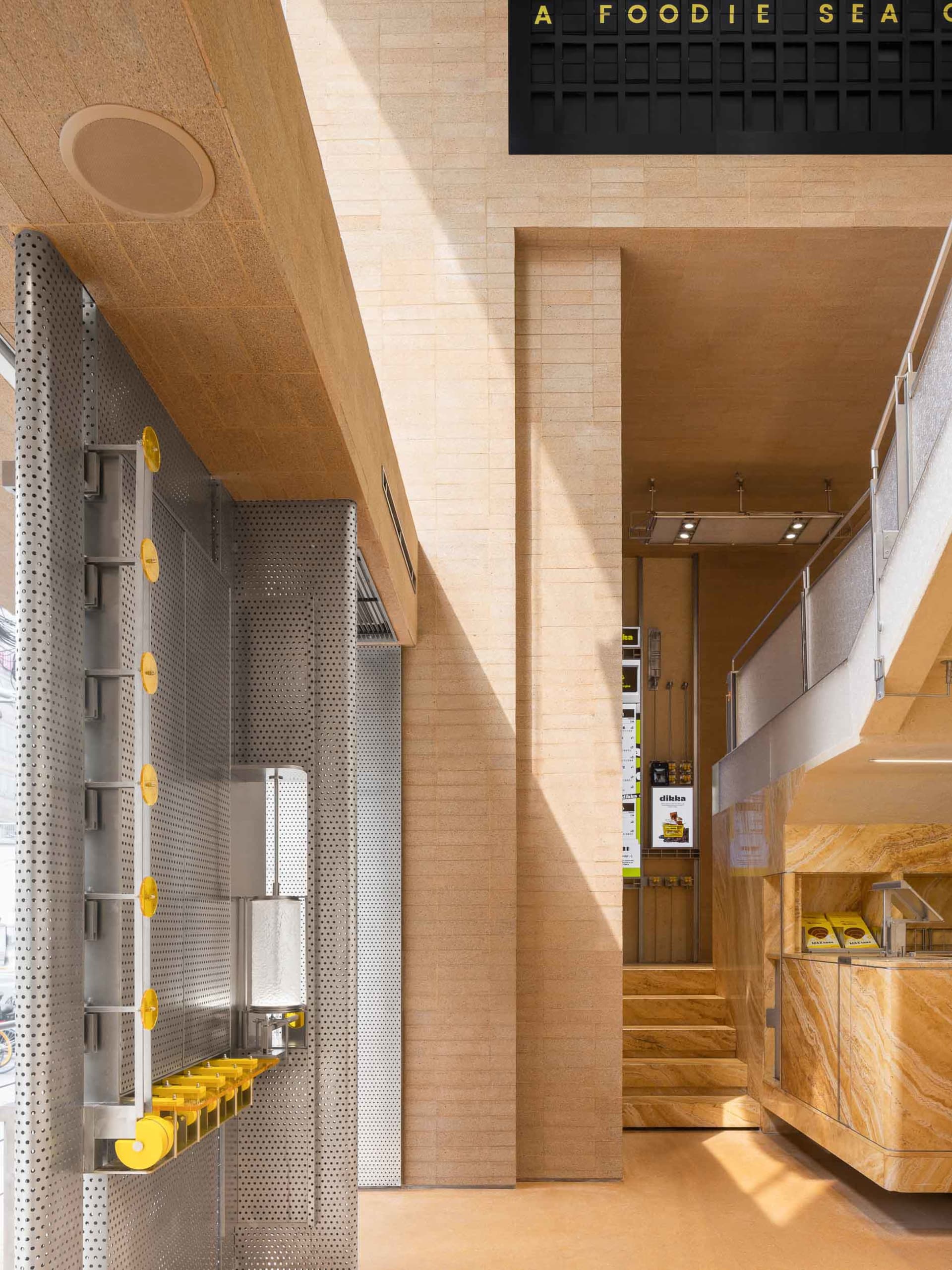 Interior of a modern coffee shop featuring a stone exterior and minimalist design.