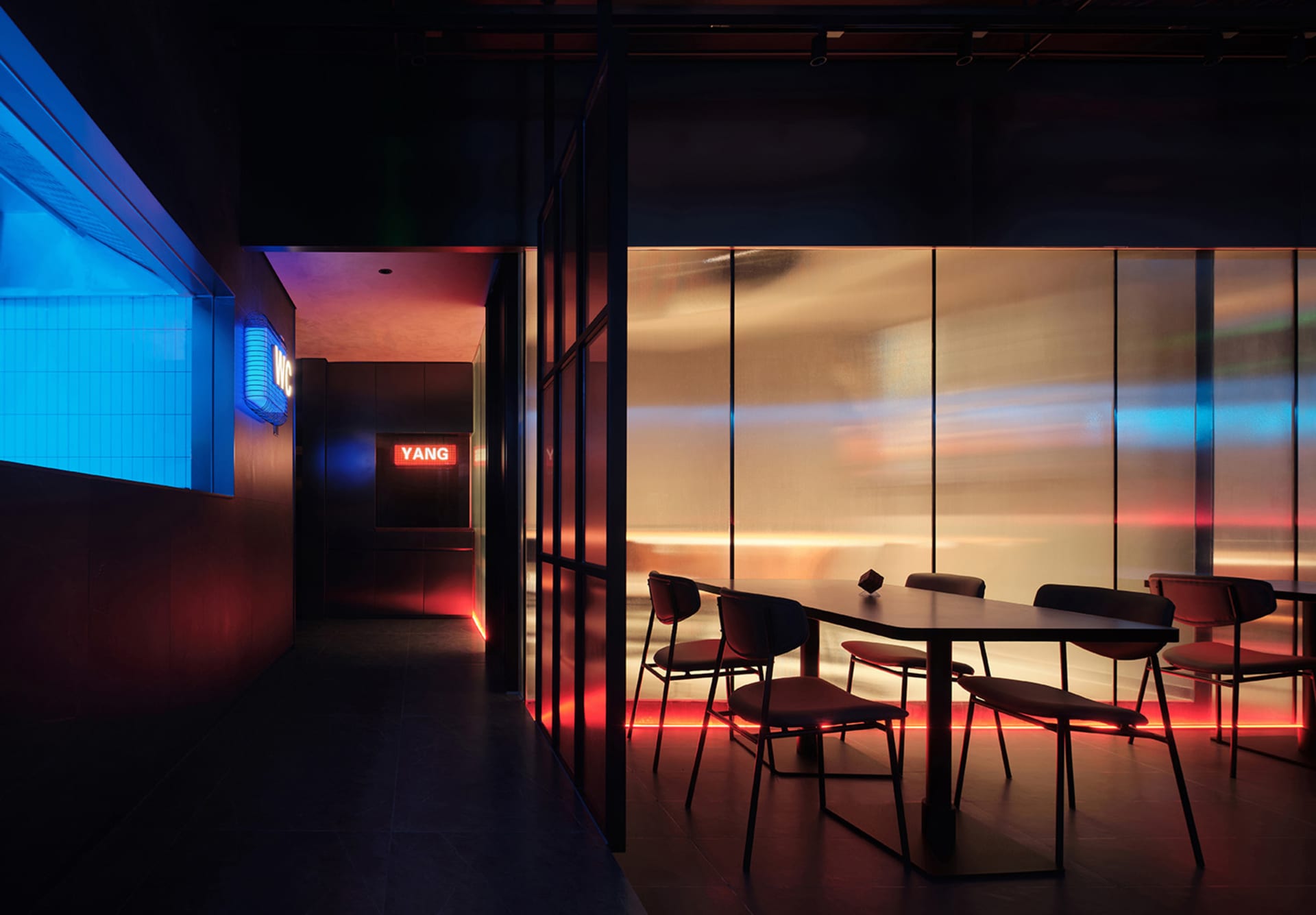 Modern minimalist restaurant featuring glass curtain walls and ambient lighting.