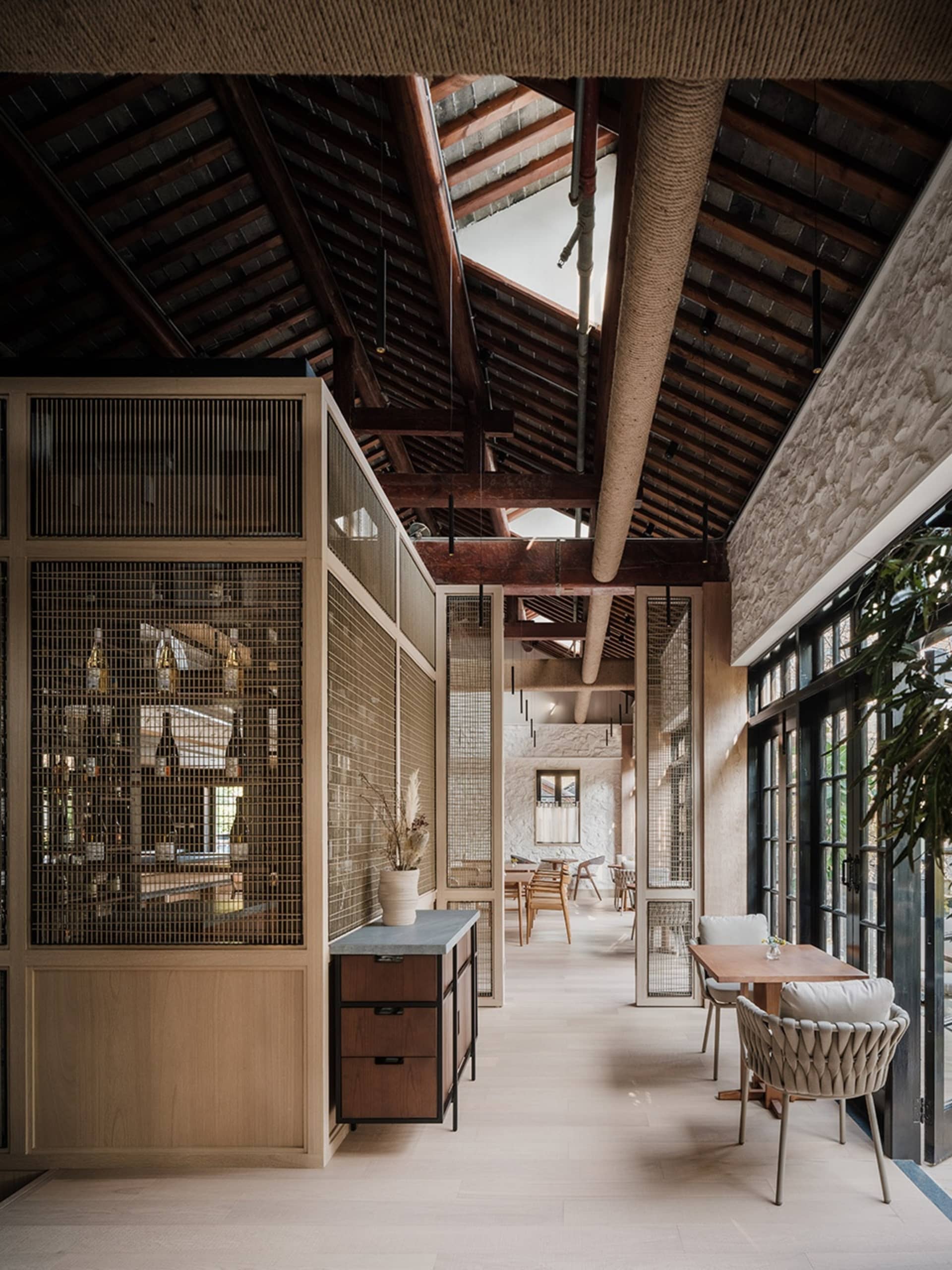 A modern restaurant interior featuring wood, stone, glass, and metal materials