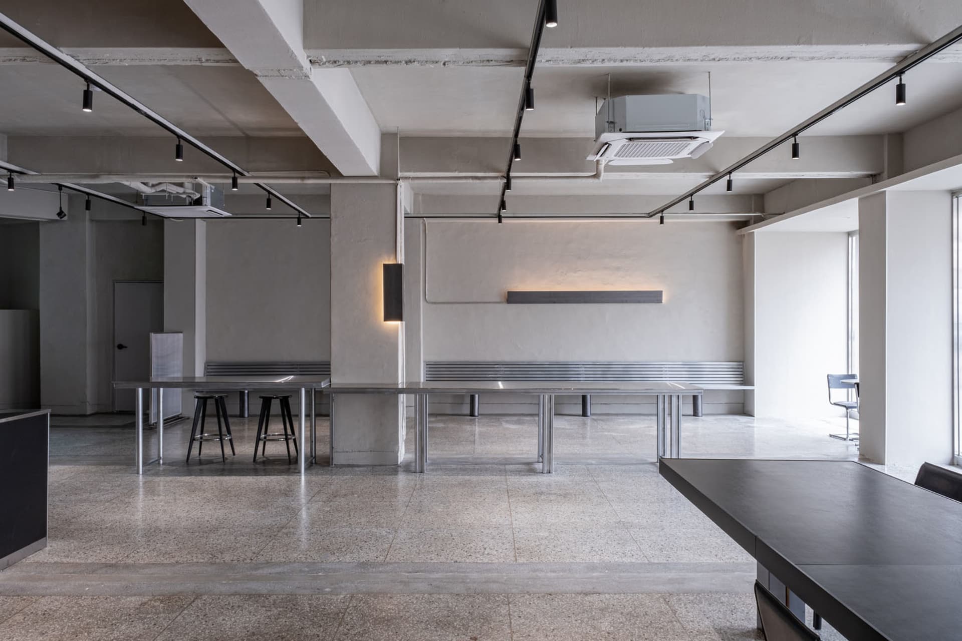 Modern industrial office space featuring concrete, metal, and glass materials.