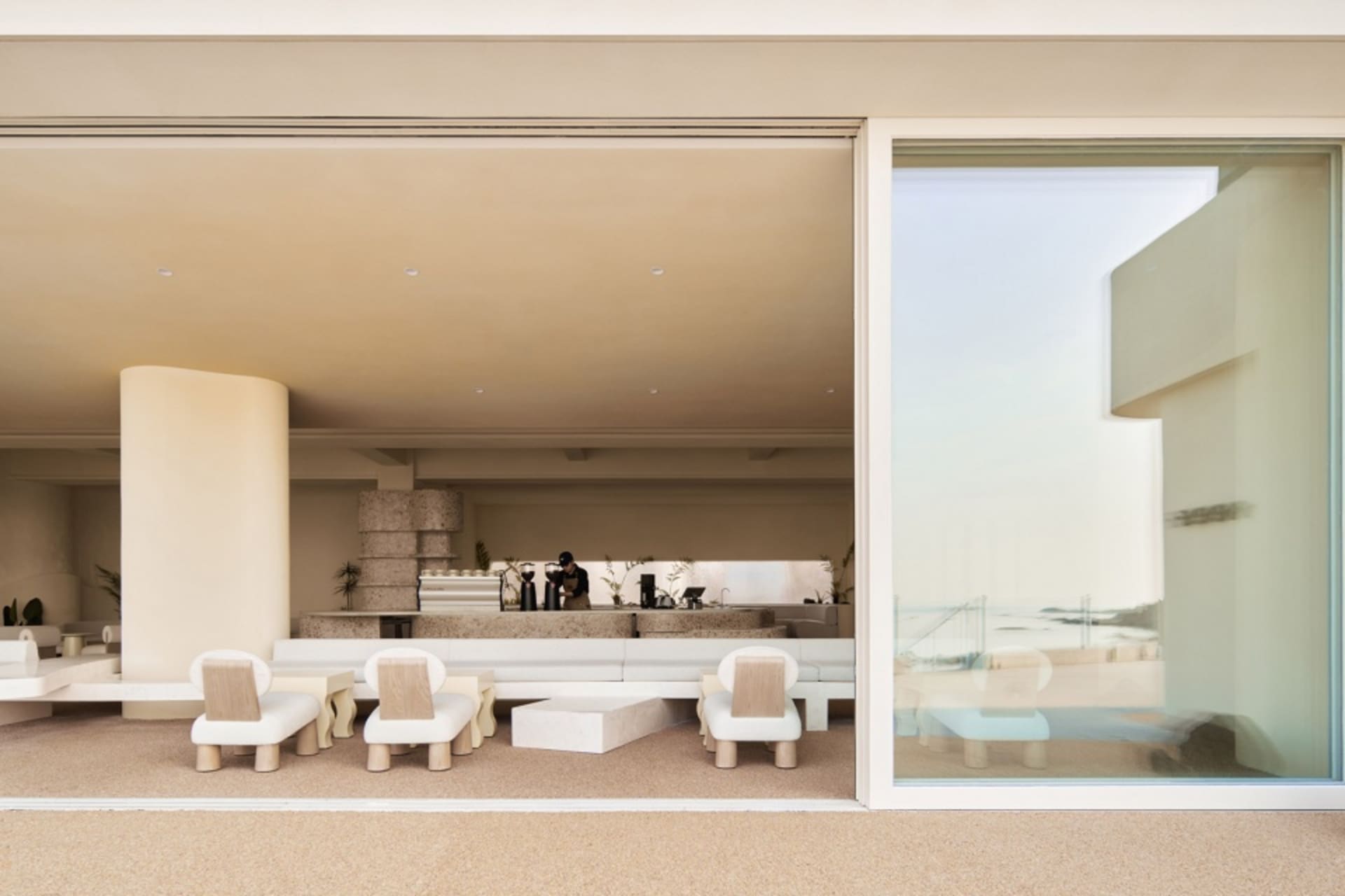 Modern minimalist living room with concrete walls, floor, and furniture.