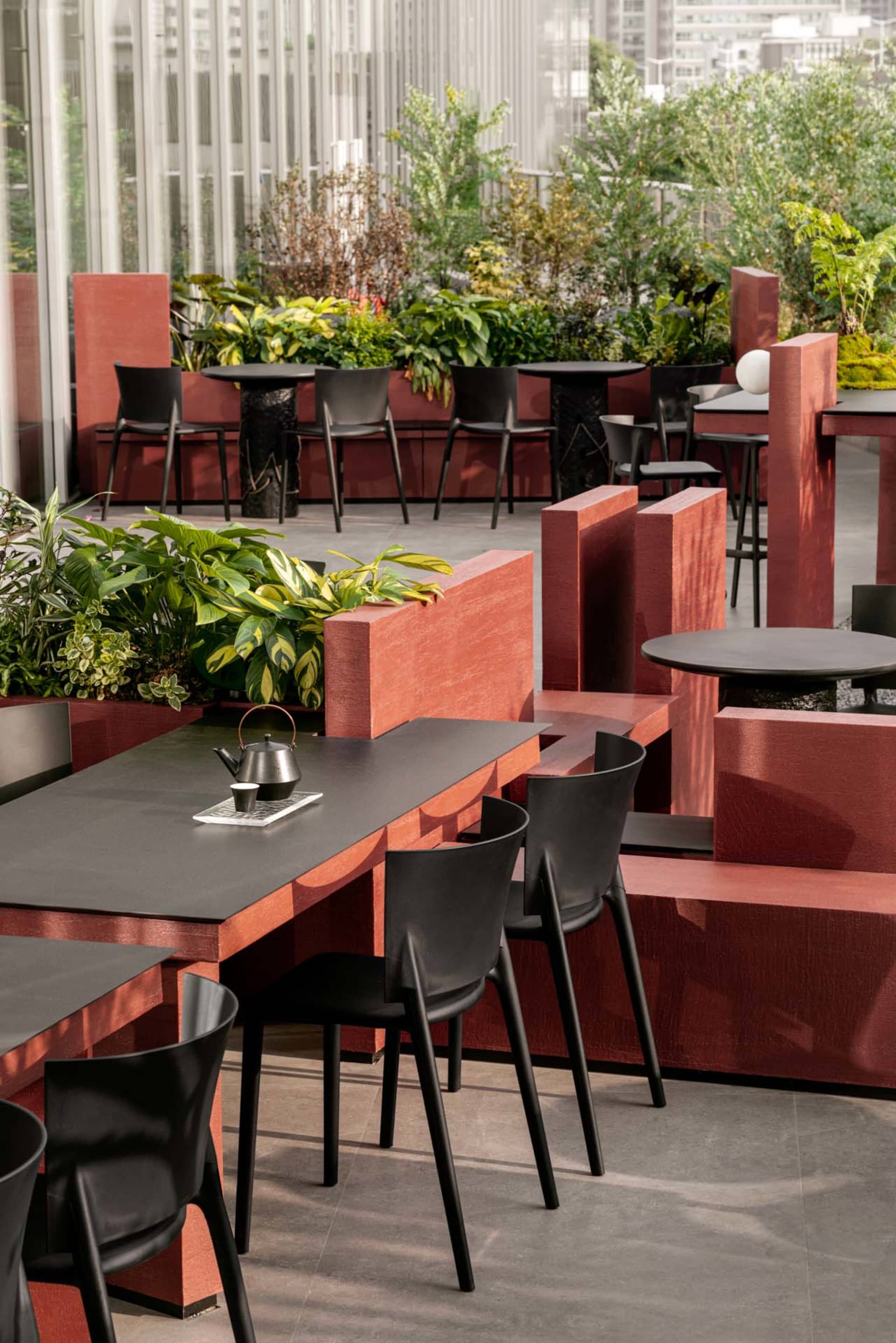 Outdoor rooftop cafe with modern, industrial design featuring metal, concrete, and wood materials.