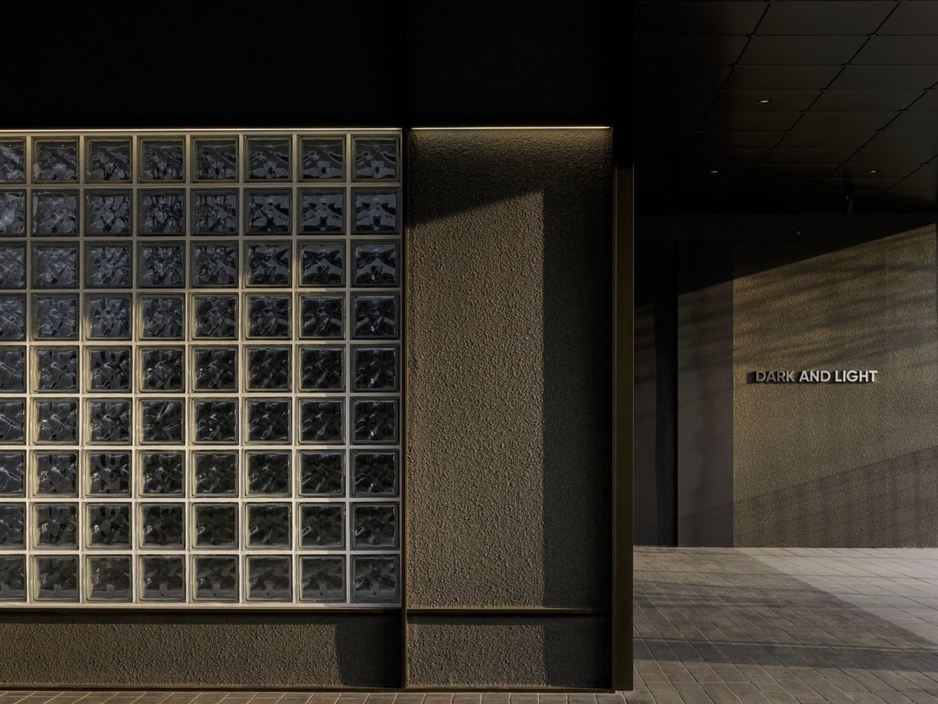 Contemporary interior design featuring glass block walls and contrasting lighting elements.