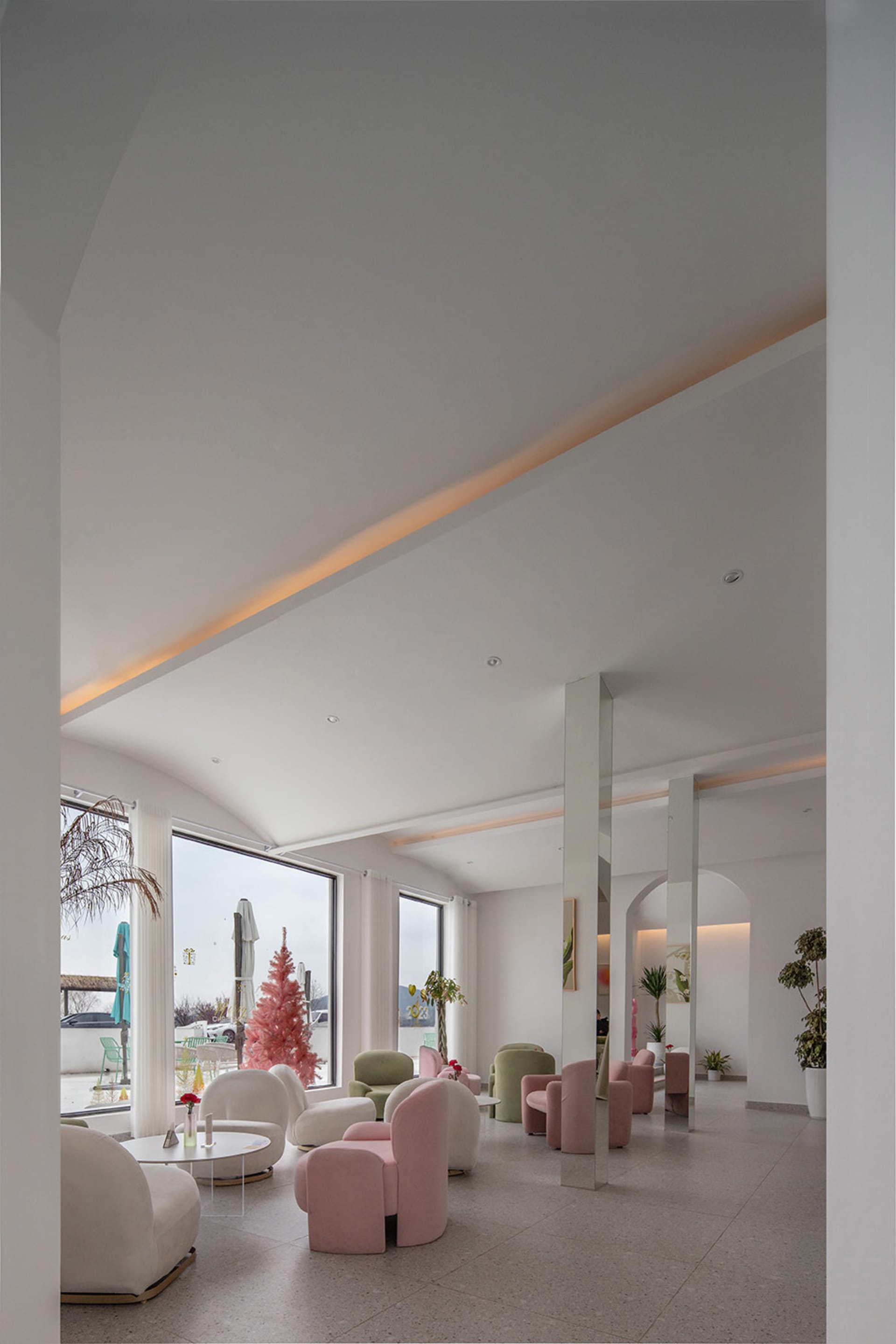 Modern hotel lobby featuring sleek, pink, and white furniture.