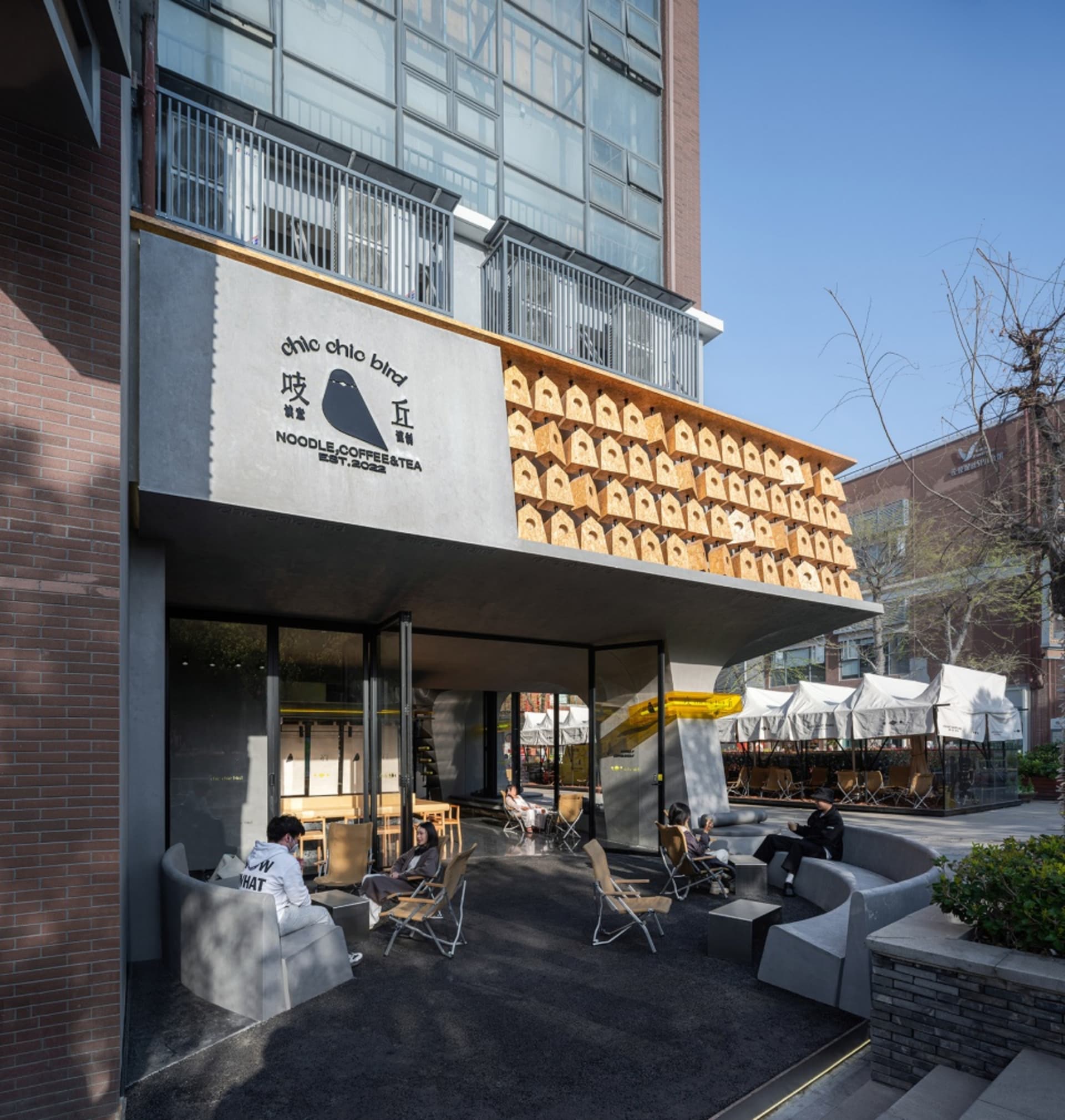 Modern restaurant exterior with wood slat wall and minimalist design.