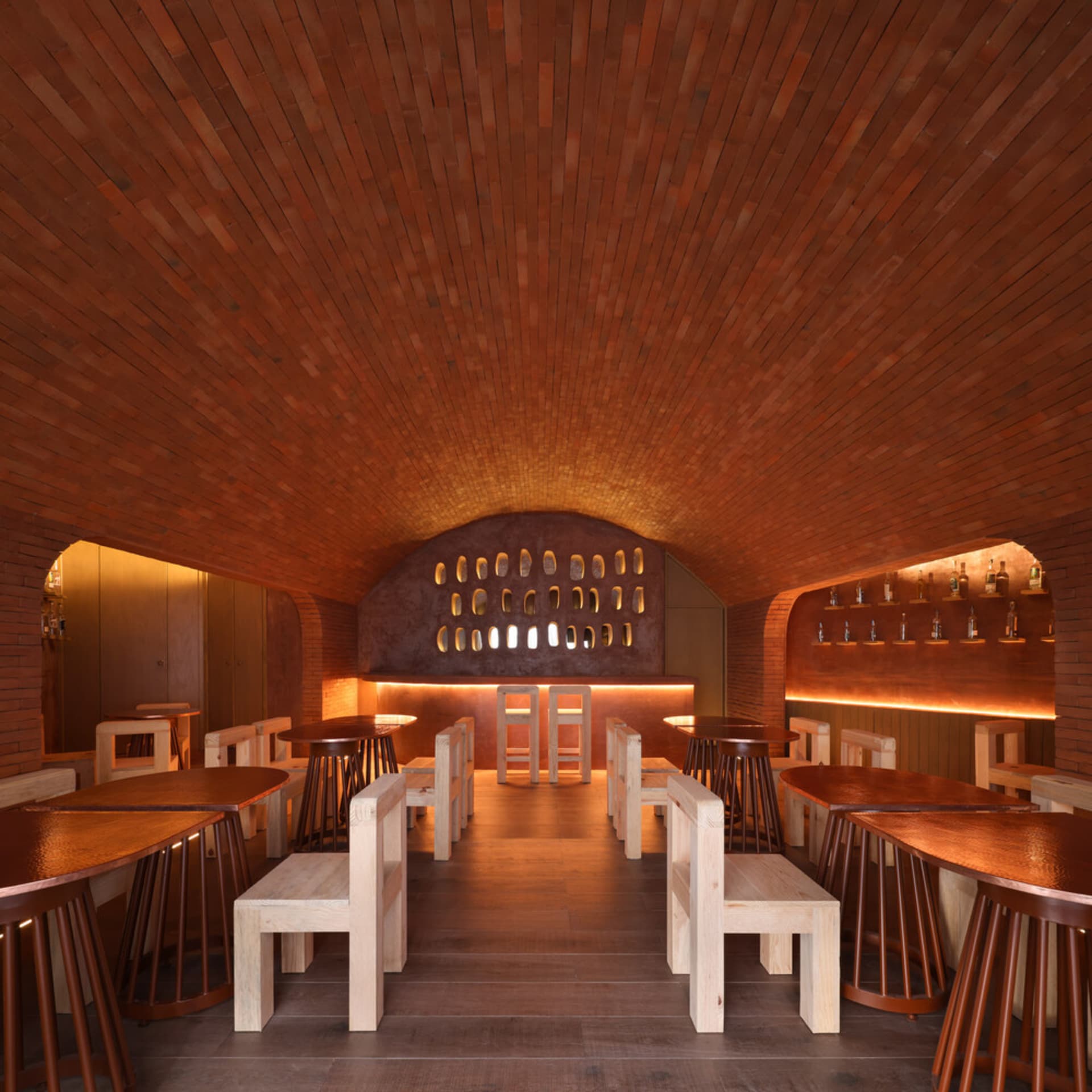 Industrial-style restaurant interior with brick walls and wooden tables and chairs.