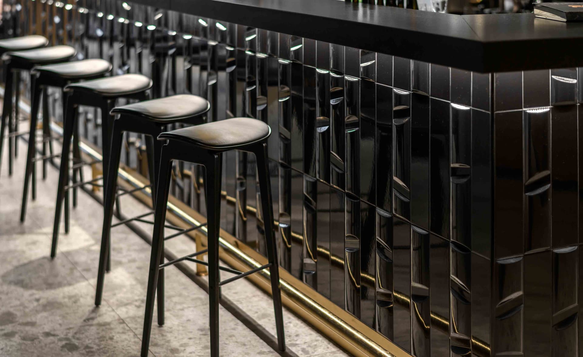 A modern industrial restaurant interior with a sleek, metallic bar counter.