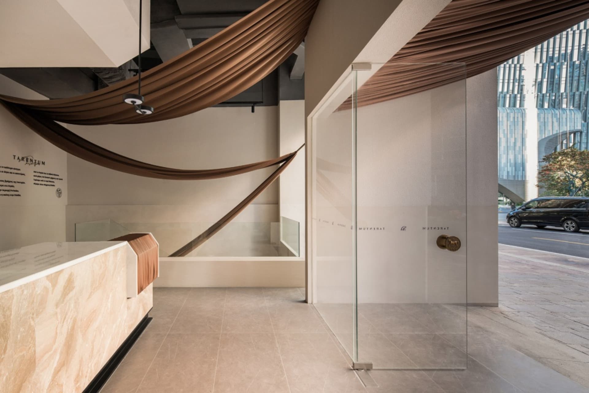A modern minimalist retail storefront with glass, marble, and concrete materials.