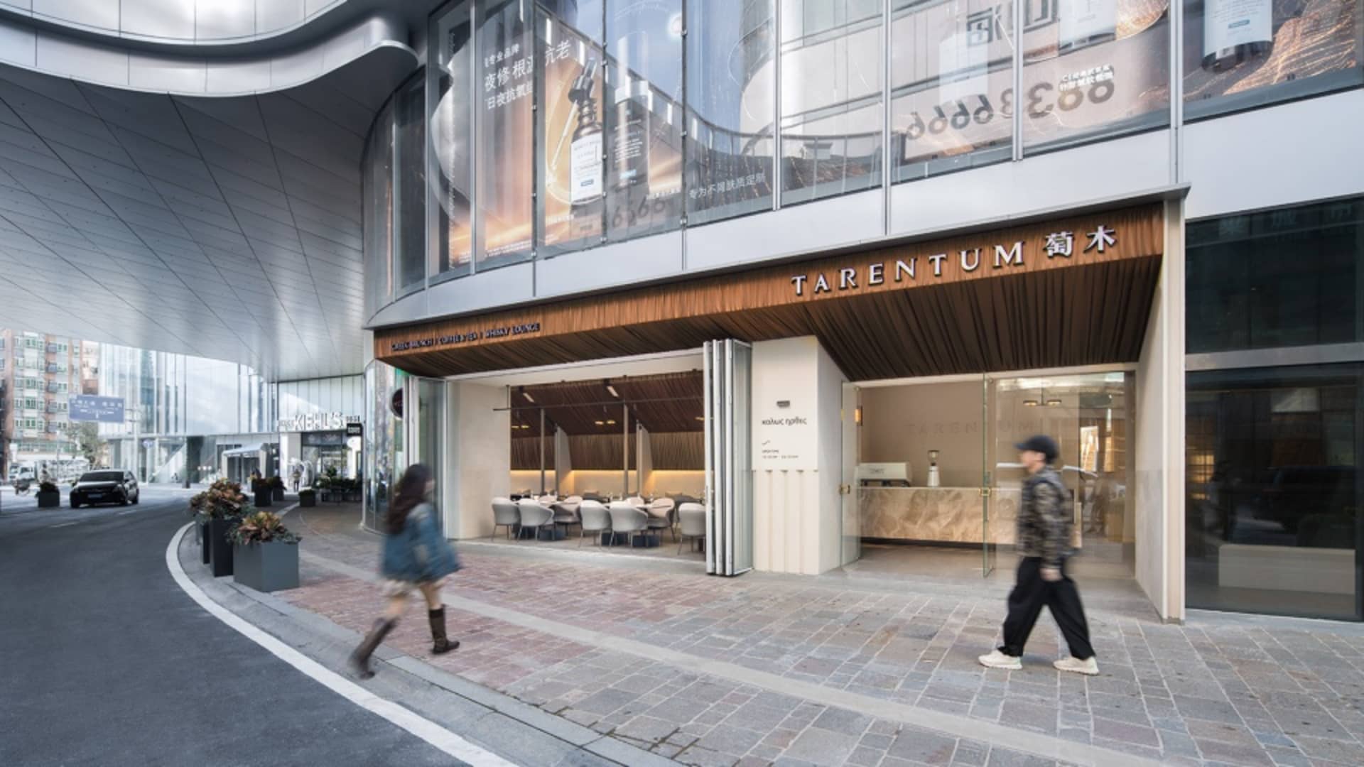 現代餐廳擁有玻璃店面與混凝土入口，位於人行道上。