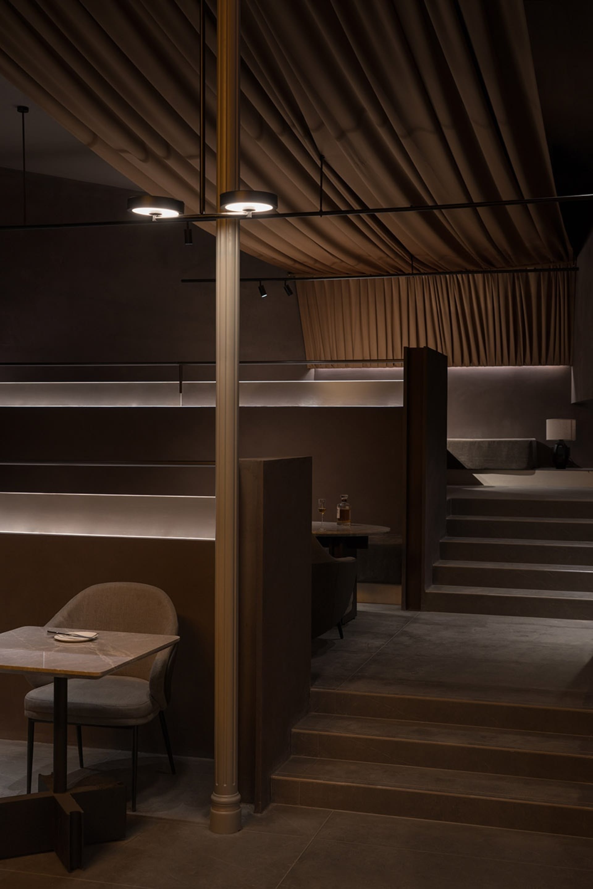 Restaurant interior with fabric curtains and concrete elements