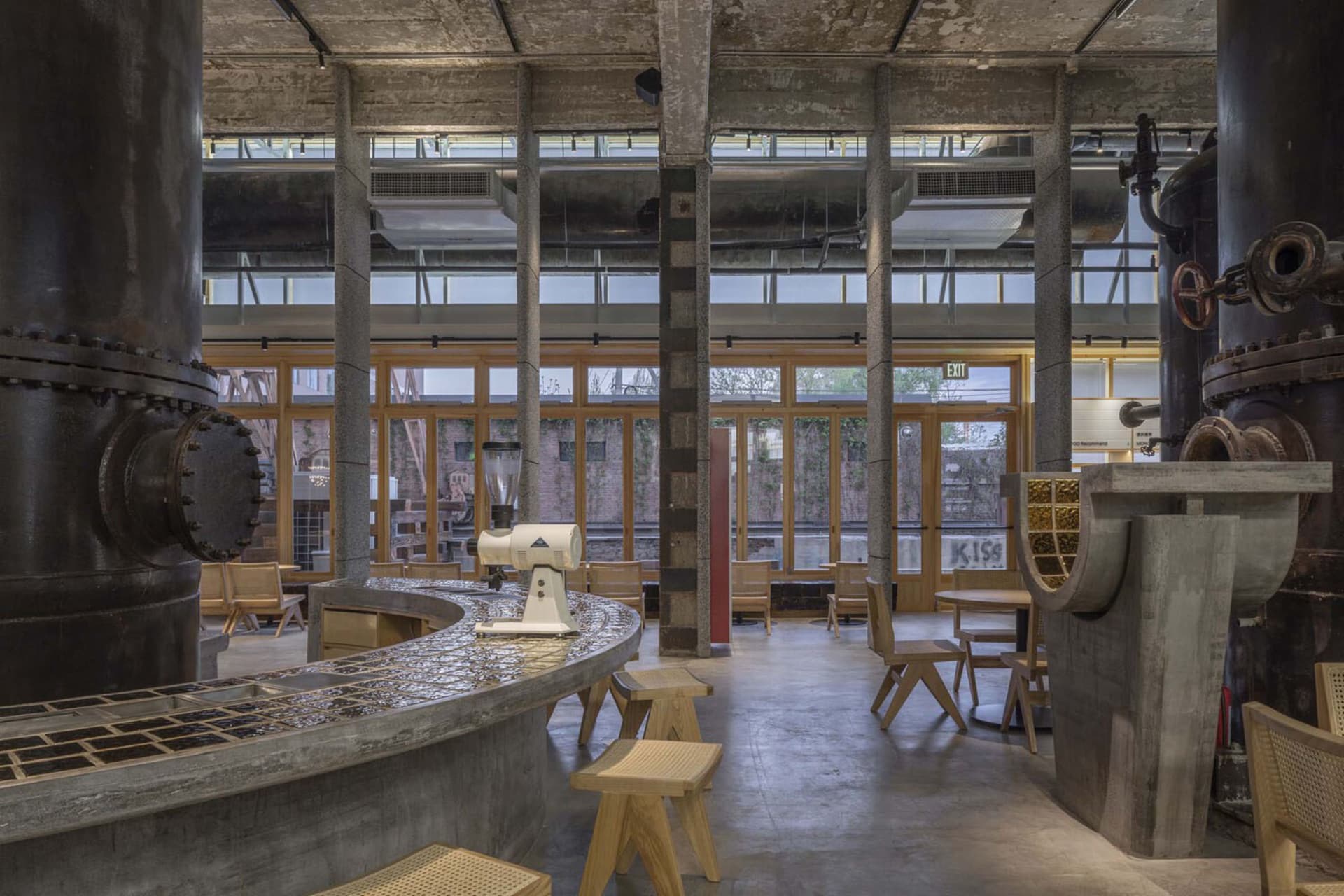 Industrial-style coffee shop with concrete bar and seating area.
