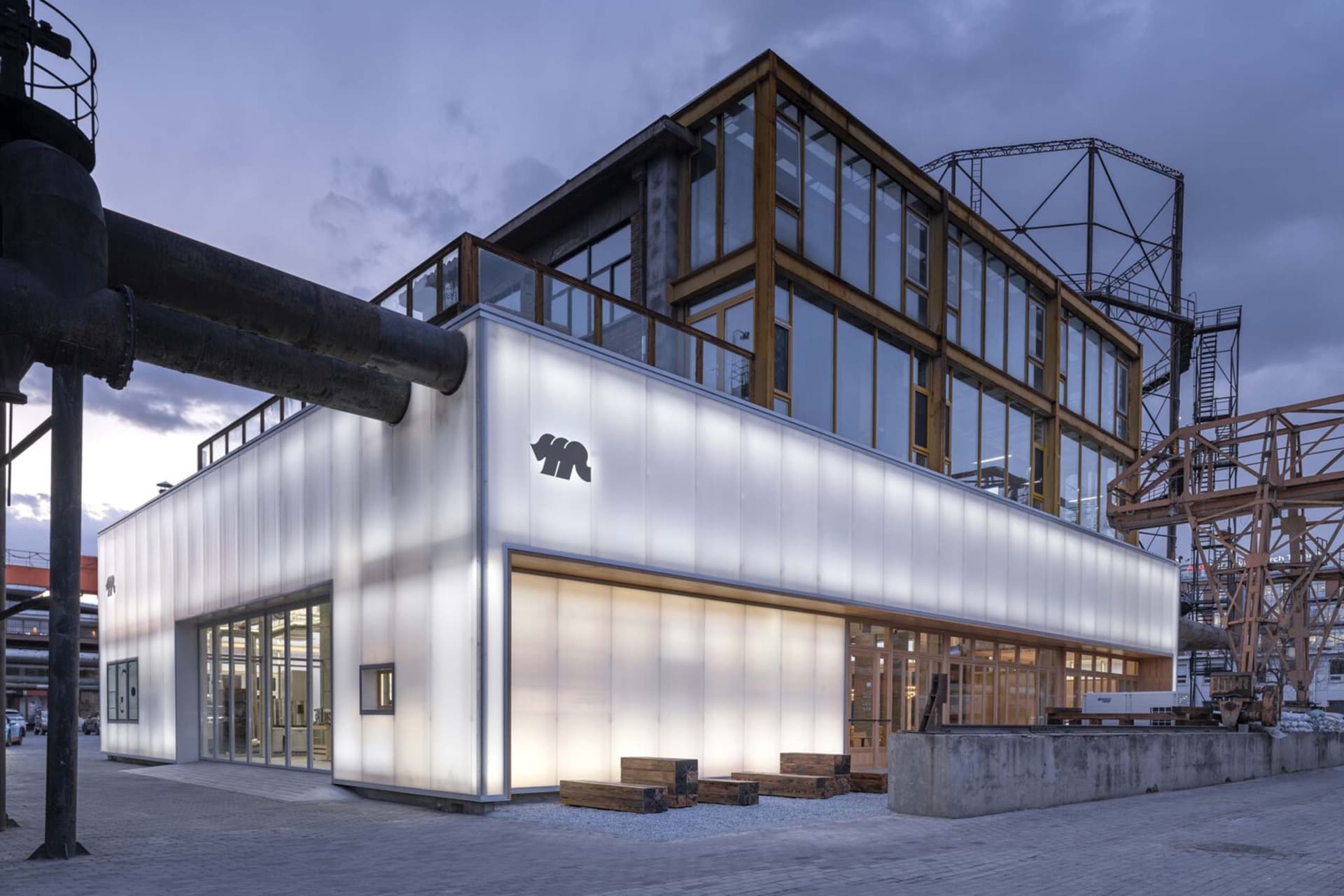 Industrial building facade with illuminated glass panels and concrete structure