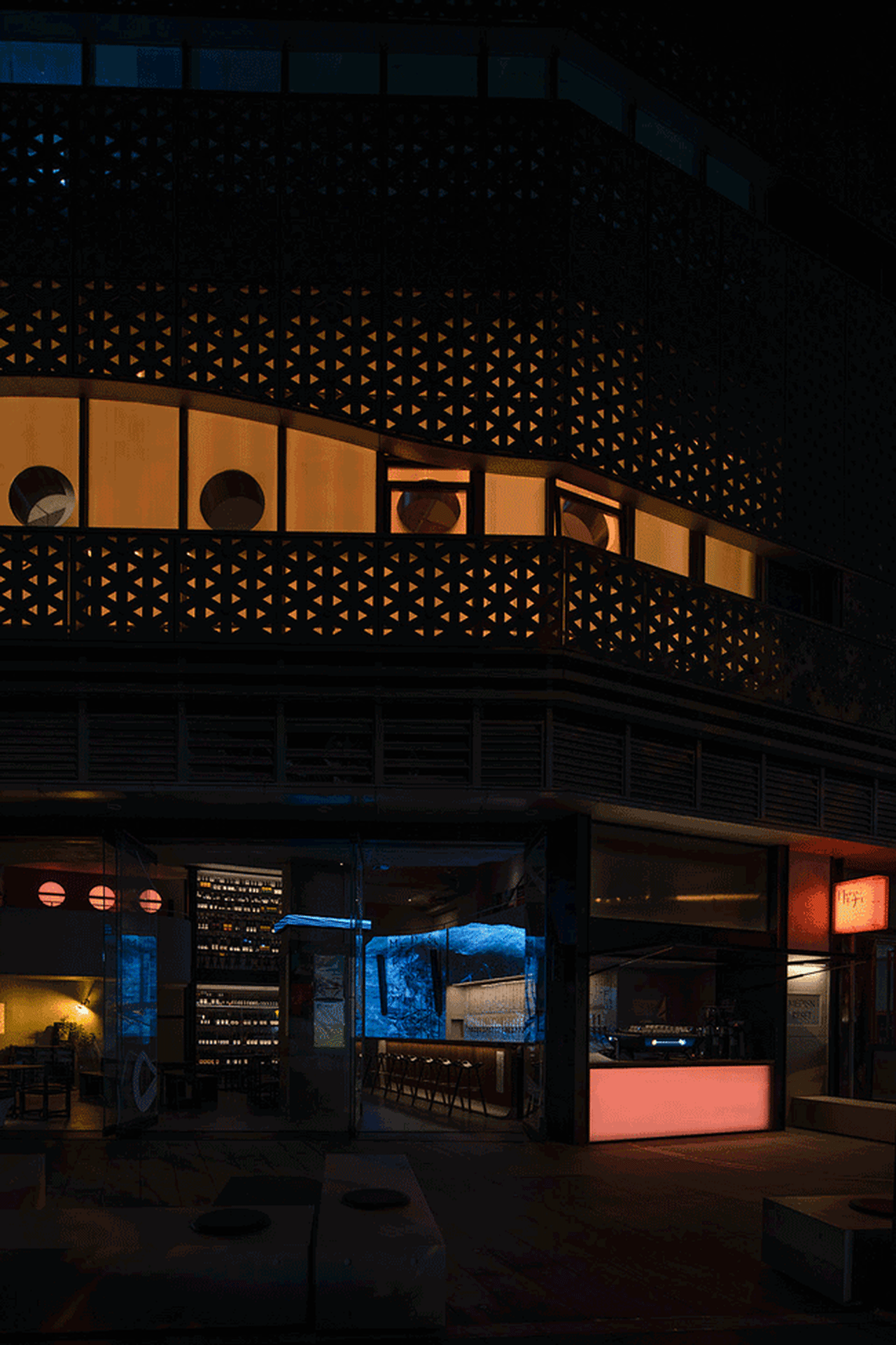 A modern bar interior featuring metal elements and warm lighting.